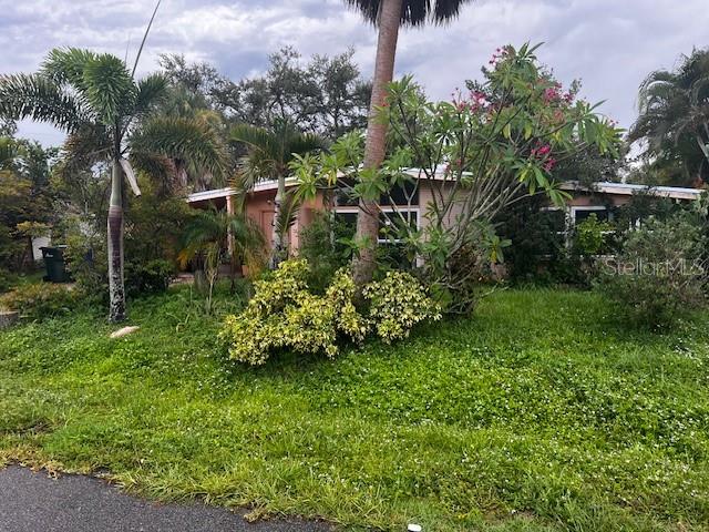 Motivated Seller - Great Potential to transform this Mid-Century Home to it "Best Version of Itself" as is has Great Bones, which include; Newer Roof, Newer Windows, wooden beam ceilings, original terrazzo floors and is situated on an a large, private, corner lot with an abundance of trees and beautiful flowers. The house was redesigned to have an attached, yet separate quest space, with its own private entrance. Overall the house is quite unique and could be ideal for someone with a creative vision that can see it for its true potential. The neighborhood is not- Ordinary, as there are Million Dollar Waterfront Mini-Castles (across the street) among small cottages and mobile homes in this Non Deed Restricted, very centrally located to the best of Vence and Sarasota. Last year with the hurricanes, the owner states this home did not flood, yet the house is a stone thrown to the water, leading to the Gulf. This is a Potential Short Sale, so all offers need to be submitted through the portal indicated in MLS