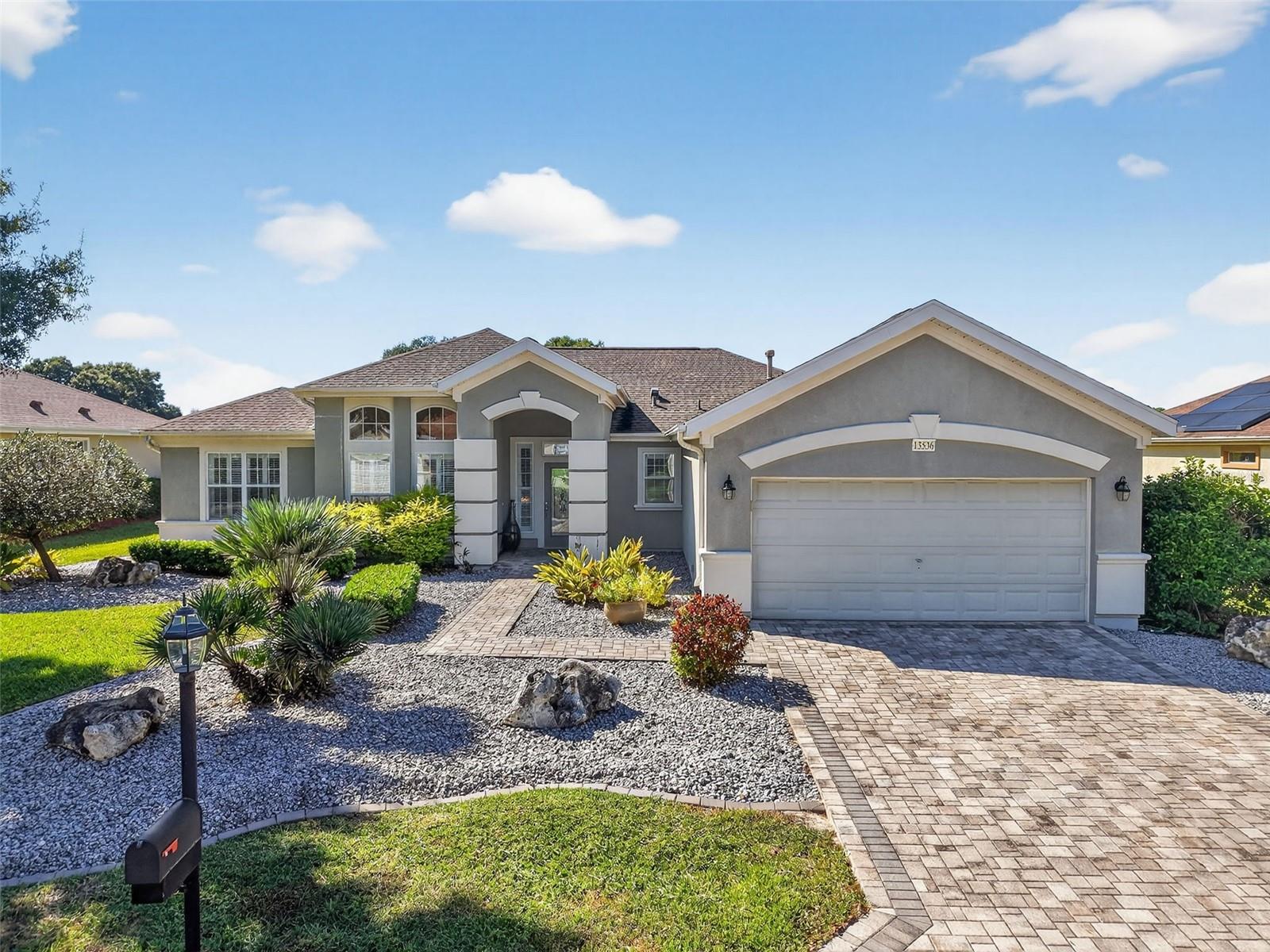 Beautiful home in Del Webb Spruce Creek Golf & Country Club located on the 8th fairway of the Heritage golf course.  From the moment you arrive, you'll notice the paver driveway and walkway.  Inside you'll find plantation shutters throughout and no carpeting, just beautiful ceramic tile and hardwood floors for easy maintenance.  Eat-in kitchen features an elegant arched window, quartz counter tops, pullouts and stainless steel appliances.  A cozy breakfast nook features built-in hutch and desk which adds both charm and functionality.  The split floor plan offers privacy and comfort.  Master suite includes a lovely bay window overlooking the golf course, master bath with dual quartz vanities, tub and shower.  The expanded front bedroom provides extra space, while the third bedroom can serve as a guest bedroom or den (no closet).  Guest bath also features quartz counters and tub/shower combination.  Enjoy golf views year-round from the glass enclosed lanai, complete with ceramic tile and shades.  The oversized garage includes a utility sink for added convenience.  Roof 2016, HVAC 2020, gas water heater 2020.  Some furnishings may be available.   Home is move-in ready and a must see!