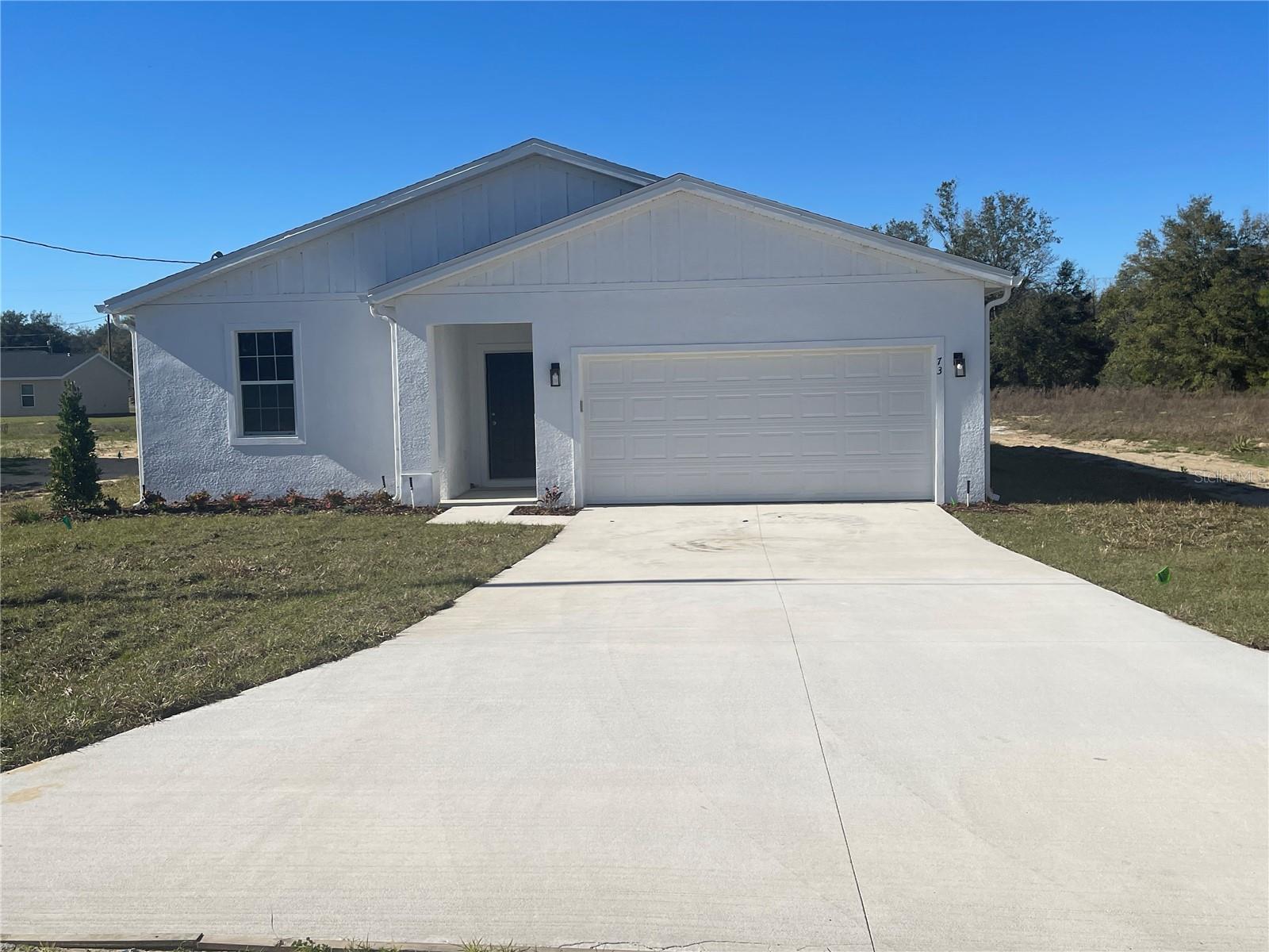 Welcome to your new home in Ocklawaha, FL!
This 3 bed 2 bath has everything your looking for. This home offers an open concept layout with the kitchen and family area combined for an airy feel. All bedrooms have carpet for your comfort, and tile throughout the rest of the home for easy clean ups. The kitchen is stocked with all your stainless steel appliances. The primary bedroom has a spacious walk in closet and private walk in shower. If thats not enough storage space then the 2 car garage is sure to entice you! No need to worry about water bills as this home has its own private septic and well water. Come tour your new home today!