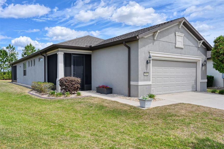 Start living your best life in this gorgeous and well maintained home offering a spacious extended screened lanai with flat screen TV, screened cage, plus open paver patio on one of the largest pie-shaped lots in Nottingham, with HOA maintained rear privacy hedges. The screened front porch with upgraded tight weave screen material and beautiful upgraded glass insert in the front door is a perfect space for receiving visitors, deliveries or enjoying sunsets with a beverage. This home contains upgraded luxury wood-look tile flooring throughout with a very neutral, appealing color palette. The open concept living room with ceiling fan, included flat screen TV & sound bar, flows seamlessly thru the dining area with tasteful chandelier into the large bright kitchen. The kitchen is full of upgrades with stainless steel appliances, expansive upgraded quartz countertops, upgraded cabinets with additional built-in cabinetry, including pull out shelves, soft close features, beautiful clear glass island pendant lights, extra ceiling can lights, and an upgraded single bowl stainless sink and faucet. This home also features a main bedroom with ceiling fan and en-suite bathroom. The larger extended tile shower stall, double sink vanity with solid surface countertops and brushed stainless fixtures, private water closet with comfort height commode, spacious clothes closet, and separate linen closet create a very functional spa-like space. The two highly desirable guest bedrooms complete with closets & ceiling fans, are perfect for hosting visiting guests, a home office, den, music room, etc; the options are virtually endless!  The conveniently located private guest bath provides easy access to a tub/shower combo and single vanity with solid surface countertop and brushed stainless fixtures. There is a very handy built-in drop zone just inside the interior garage door for ease of entry and exit, as well as clutter-free organization. The extended garage boasts an epoxied floor, water softener (owned), an upgraded hybrid water heater, utility sink, a disappearing motorized full screen door, sturdy wall mounted tool racks, and 4 heavy duty ceiling storage racks. This home in the gated community of DelWebb Stone Creek is in very convenient proximity to the main amenities complex. This Garden Home includes yard maintenance, irrigation, weekly trash/recycling pickup, & basic 100 Mbps internet within the monthly HOA fees.  Enjoy the DelWebb 55+ lifestyle of the Stone Creek community with many amazing amenities including Full Service Health and Fitness/Spa Center, Heated Resort Outdoor Pool and Heated Indoor 25 meter Lap Pool, 5 Tennis Courts, 16 lit Pickleball Courts, 8 Bocce Ball Lanes, Basketball Court, Horseshoe Pits, Community Garden, 2 Dog Parks - 1 with agility course, Softball Field, numerous Fishing Ponds and miles of walking, biking and golf cart trails. Stone Creek is socially active with a dedicated Lifestyle Director and Spa Director and over 60 clubs and interest groups to join. Stone Creek is located with proximity to golf, shopping, dining, medical services, the World Equestrian Center, local attractions and numerous outdoor activities. Stone Creek also offers a membership optional semi-private golf course, Golf Club Grille restaurant, Reunion Center Cafe, Stone Water Club Bar, Golf Simulator, activities, classes, special events, and an RV storage lot for additional fees. *All dimensions are approximate; Buyer/Buyer’s Representative to verify*