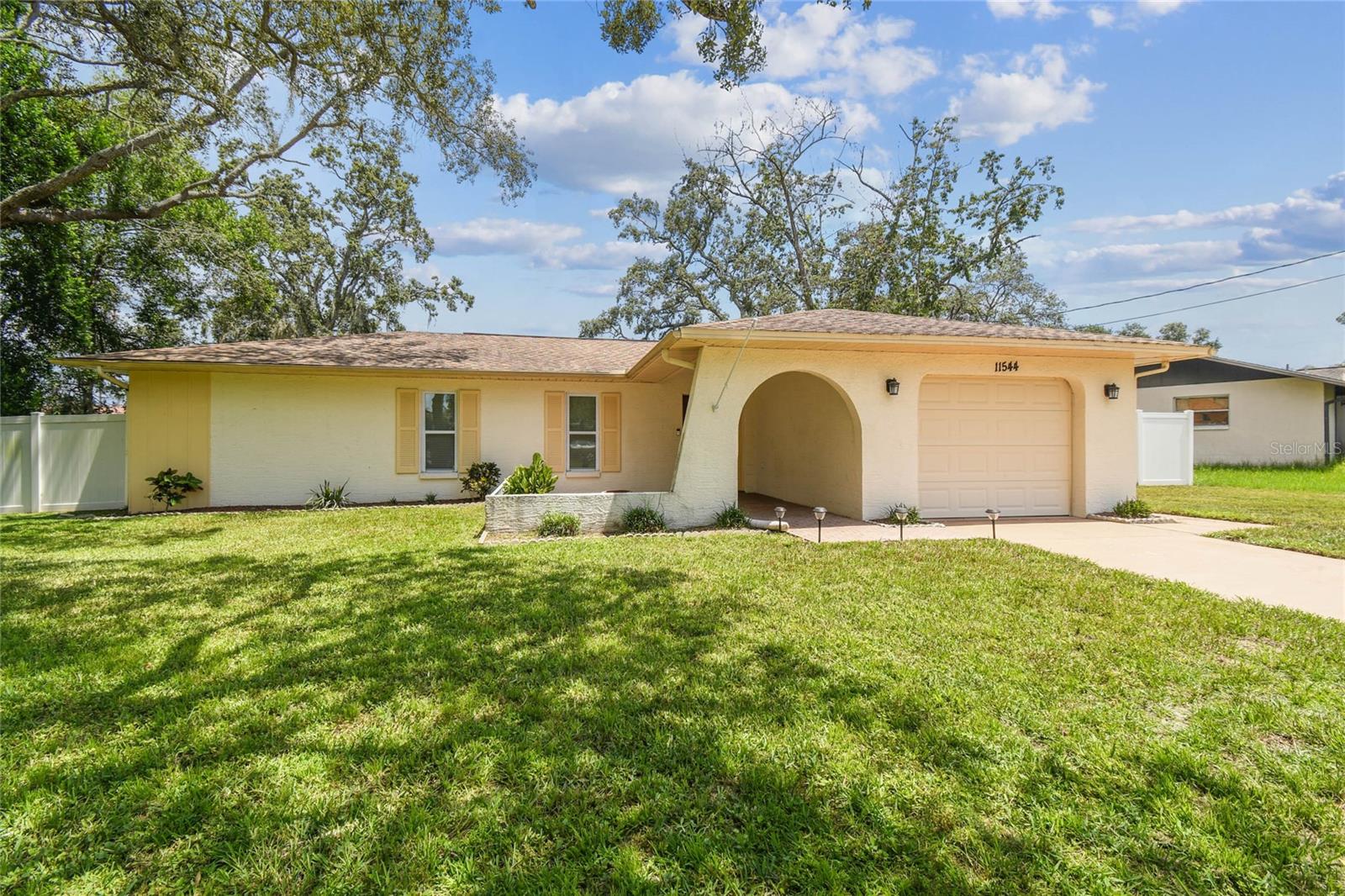 One or more photo(s) has been virtually staged. Located in the heart of Spring Hill is a cozy and welcoming 2-bedroom, 2-bathroom home set on a generously sized lot with a well designed split floor plan. This move-in ready property offers a perfect blend of comfort, updates, and outdoor space.
Inside you will find durable luxury vinyl plank flooring throughout the main living areas and tile in both bathrooms. The living room features a charming electric wall fireplace set against a striking rustic barnwood accent wall, creating a warm and inviting focal point. The kitchen is equipped with stainless steel appliances, granite countertops, a convenient breakfast bar, and flows seamlessly into the dining area and living room, making it ideal for everyday living or entertaining.
Enjoy easy access to the outdoors from the living/dining space, which opens to a covered patio and a screened-in porch with lighting, a perfect spot to gather, relax, or dine al fresco. The large private backyard is fully enclosed with brand-new vinyl fencing, offering peace and seclusion.
The primary suite includes a walk-in closet, a granite vanity, and a walk-in shower, while the second bedroom and bath are placed on the opposite side of the home for privacy.
Additional highlights include an oversized garage with washer and dryer, shelving, and a workbench, great for storage, hobbies, or DIY projects. Main system updates include a new electric panel (2022), new water heather (2022) roof (2013), and HVAC (2014). Impact sliding glass doors with built in blinds, updated windows. Epoxy coating garage floor.
This charming home is ready for its next chapter, ideal for first-time buyers, or those looking to downsize without sacrificing space or style. There is no HOA or CDD restrictions. No flood zone - No flood insurance required. Not in an evacuation zone.