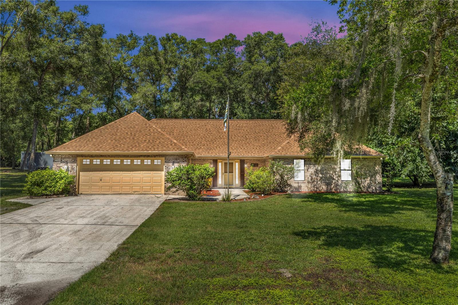 Welcome to your peaceful escape! Private 1.29-Acre Retreat with Workshop, No HOA! Nestled on a serene, tree-lined 1.29-acre lot, this beautifully maintained 3-bedroom, 2-bath brick ranch offers space, character, and freedom—plus a detached 30’ x 20’ powered workshop perfect for hobbyists or small business owners. Inside, the open layout is filled with natural light and features vaulted ceilings, engineered hardwood floors, new carpet, and a cozy wood-burning fireplace. Multiple hurricane-rated sliding glass doors seamlessly connect indoor and outdoor living, opening to a spacious backyard perfect for entertaining, gardening, or relaxing under the stars. The custom kitchen is a chef’s dream featuring custom dark maple soft-close cabinetry, granite counters, a farmhouse sink, and a center island with seating. The private bedroom wing includes a generous primary suite with walk-in closet and patio access. The ensuite bath features custom cabinetry, stylish lighting, and a glass vessel sink (seller has an additional vessel sink if Buyer wanted to add it). Two additional bedrooms share a well-appointed hall bath. Recent upgrades include a BRAND-NEW roof (2025) and fresh interior paint. Additional highlights: oversized 2-car garage and utility sink, indoor laundry, chicken coop includes chickens, and even a large mulberry tree—perfect for making jam, wine, or enjoying fresh fruit! Big gun safe included. Tucked away in a quiet community with mature trees, yet close to local shops, parks, music/art venues, and beautiful natural springs. Schedule your private tour today and discover all the possibilities! Property may be under audio/video surveillance.