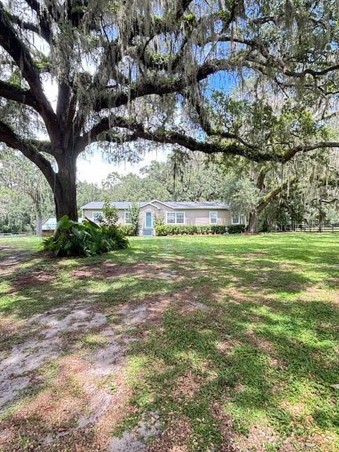 You've always had your heart set on THAT mini farm...Sitting under a canopy of Majestic Oaks, with the perfect sized barn and a large air conditioned Tack/Workshop for your aspiring hobbies. Another 16x16 storage barn for farm equipment. Two plush pastures for your equine friends. YOU HAVE JUST FOUND IT on this 2.91 acres!! Then let me tell you about the Customized '09 Nobility Manufactured Home. Over 2000 sq ft. of New Roof, New HVAC, Gourmet Kitchen, Remodeled Bath and large covered back Deck. The Island Kitchen has Stainless Steel appliances, spacious bar area for entertaining, 2 sinks, a 5x9 walk-in Pantry has tons of storage space...even a window! Mudroom/Laundry area has the back door entry from the Deck, 2 closets, a pass through for clothes from Master bath and a Farmhouse Hall Tree w/bench...oh, it is gated as well. The openness of Family Room, Dining and Kitchen creates the split bedroom plan. Large Master Suite w/ gorgeous remodeled Bath is at one end of the home and the 3 additional Bedrooms w/Bath 2 is at the other end. The 12x36 covered Deck runs across the back of the house. It is railed and is gated at the steps. The porch swing is a great place to unwind from the day and watch the beautiful Sunsets. The airy barn has (3) 12x12 matted stalls that sit across the aisle from the Wash Rack and Tack/Feed/Workshop. This has doors and windows at both ends, so space could be divided to accommodate 2 separate rooms. The acreage is completely fenced with manual gate at entrance. This property is just approx. 8 miles West of I 75, 10 minutes from the World Equestrian Center, H.I.T.S., shopping, dining, feed stores and entertainment close proximity. Shown by Appointment Only. Listing Agent must accompany showings.