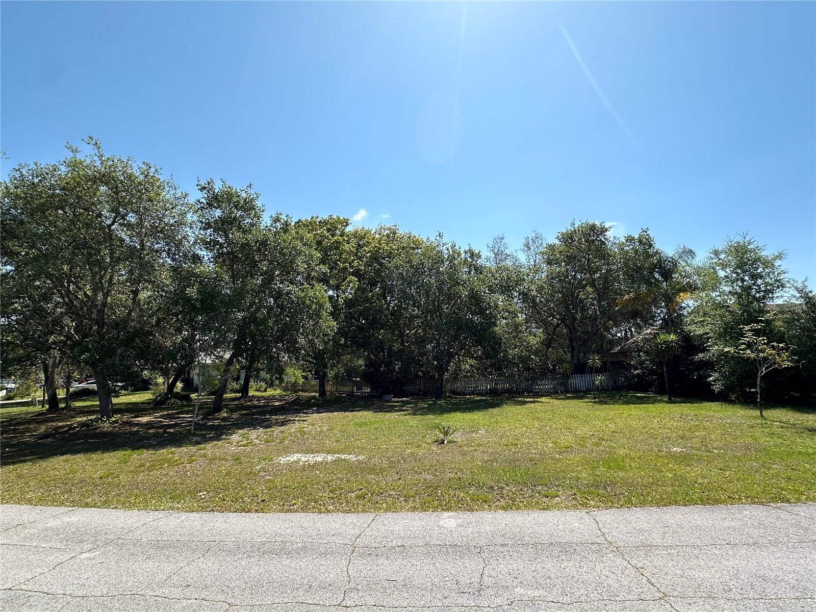 A vacant lot, just over a quarter acre in size, holds a universe of potential within its boundaries. This unique piece of land, embraced by lush, mature trees that promise shade and tranquility, becomes a canvas for the imagination. It's cleared, level ground whispers of endless possibilities, inviting dreams of a future home to take root. The fact that it is zoned for residential use opens the door to various visions of domestic bliss, from a cozy cottage enveloped in nature's embrace to a modern, eco-friendly home designed with sustainability in mind. Envisioning the future of this vacant lot, it's easy to imagine a space that becomes more than just a residence. It could evolve into a personal retreat, a gathering place for friends and family, or a haven for creativity and relaxation. The key to unlocking this potential lies in thoughtful planning and a deep appreciation for the land's inherent qualities. With its blend of natural beauty and readiness for development, this quarter-acre plot is not just a piece of land; it's the groundwork for a dream waiting to be realized.