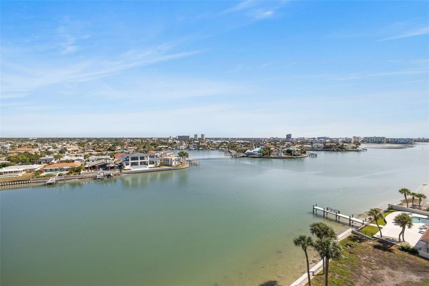 WATERFRONT CORNER UNIT with panoramic Gulf and Intracoastal views in the luxury gated Yacht & Tennis Club of St. Pete Beach. This 9th-floor condo boasts stunning Gulf views from the front and side balconies and Intracoastal views from the rear, offering nearly daily sunsets and beautiful sunrises. Enjoy coastal living in this 2-bedroom, 2-bathroom home with wraparound balcony showcasing both the Gulf of Mexico and Intracoastal Waterway. Inside, the 1,310 sq ft open floor plan features a galley-style kitchen with an eat-in area, a primary suite with a walk-in closet and en-suite bath, a guest room, and a second full bath. Additional highlights include in-unit laundry, sliding windows and doors, and storm shutters. Recent community updates include a completed seawall project, landscaping upgrades, refreshed courts, and a new kayak launch coming soon. Amenities include 24-hour gated security, a large heated waterfront pool and spa, fitness center, tennis and pickleball courts, marina with boat slips, clubhouse, saunas, shuffleboard, and BBQ areas. Just a short walk to the beach, restaurants, and shops, and within easy reach of Tampa International Airport and downtown St. Pete. Schedule your showing today.