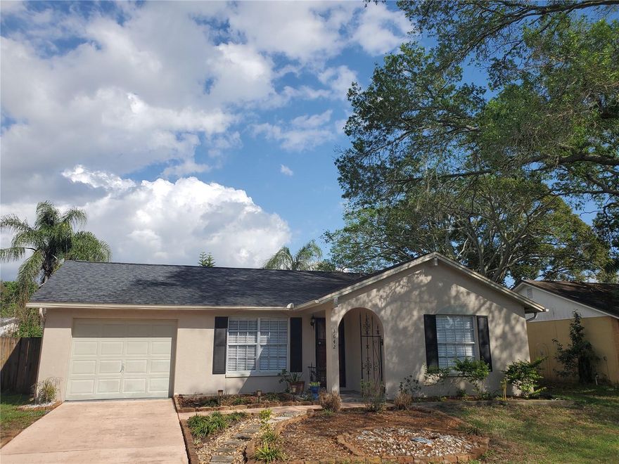 Step into this charming and thoughtfully updated 2-bedroom, 2-bathroom home with a 1-car garage—where comfort meets effortless style in every corner.  From the moment you arrive, the inviting curb appeal and mature landscaping set a warm, welcoming tone. Inside, you’ll find a bright, open living space with soaring ceilings and abundant natural light that gives the home an airy, relaxed feel.  The kitchen is both stylish and functional, featuring sleek countertops, modern appliances, and crisp cabinetry—perfect for everything from quick breakfasts to cozy dinner nights. Just beyond, sliding glass doors lead to a spacious screened-in lanai, creating a seamless indoor-outdoor flow ideal for morning coffee, evening unwinding, or hosting friends with a breeze drifting through.  Both bedrooms are generously sized with beautiful flooring and ample closet space, offering peaceful retreats at the end of the day. The primary suite includes a beautifully updated en-suite bathroom with a walk-in glass shower and elegant finishes, while the second bathroom features a clean, modern design perfect for guests or family.  Additional highlights include updated flooring throughout for a cohesive, modern look, fresh, neutral tones ready for your personal touch, dedicated laundry area in the garage with extra storage space, and a spacious backyard with room to relax, garden, or play.  Whether you’re a first-time buyer, downsizing, or looking for a turnkey investment, this home checks all the boxes with its blend of charm, functionality, and updated features.