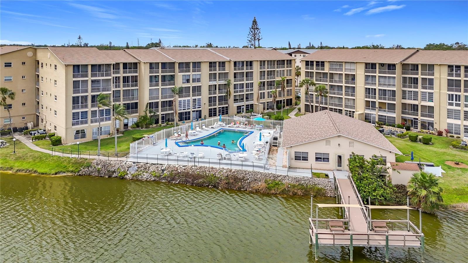 PENTHOUSE PERFECTION!! Absolutely Stunning Pool & Lake Views! New, New, New… and Views Galore! This FURNISHED 1-Bedroom, 1-Bathroom Condo on the coveted 5th Floor is a rare gem offering modern upgrades and incredible scenery. Recent Upgrades Include: Sleek KITCHEN REMODEL (2024) with stylish finishes and a BRAND-NEW REFRIGERATOR (2025). NEW LUXURY VINYL FLOORING throughout (2024) for a seamless and modern look. BRAND NEW A/C (March 2025) with a 10-Year Transferable Warranty! Newer Water Heater for worry-free living. Updated Lighting and Ceiling Fans to brighten up the space. New Screen Front Door to allow fresh breezes through the unit, complemented by hurricane sliders for added protection. Breathtaking Views & Outdoor Living! Skip the hassle of community laundry! This condo comes with its own WASHER & DRYER, offering added convenience and privacy! Relax on your private lanai with serene lake and pool views or take a stroll to the fishing pier and enjoy the benches along the gigantic lake. Cool off with a dip in the heated pool after a day of enjoying the Florida sunshine. Prime Location & Vibrant 55+ Community. Located just 8 miles from the beach and minutes from shopping and dining, this condo offers the perfect balance of convenience and leisure. This active 55+ community is where you’ll meet friendly neighbors and make lasting connections. Don’t Miss Out! This condo is as adorable as the community itself, so start living the Florida dream!