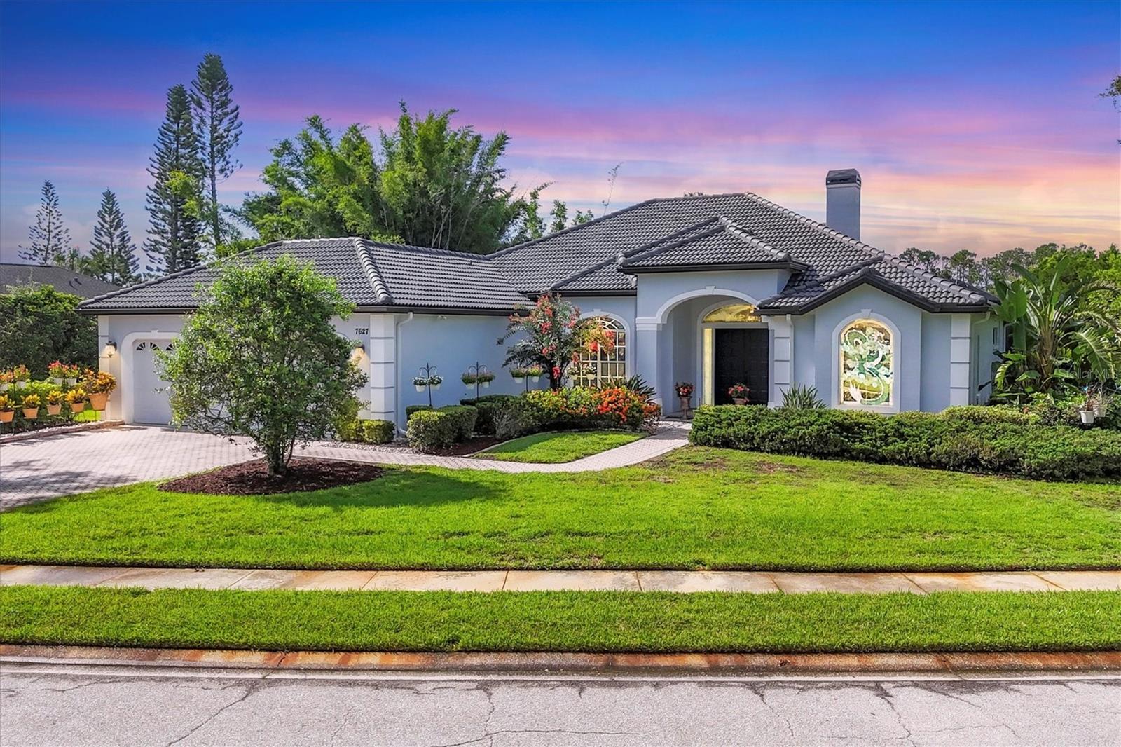 Welcome to 7627 Partridge Street Circle, a beautifully designed residence located in the highly sought-after River Club neighborhood in East Bradenton. Known for its spacious custom homes, generous lots sizes, low HOA fees, and no CDD, River Club offers a peaceful setting with mature landscaping, winding roads, and a public golf course—while still being just minutes from Lakewood Ranch, top-rated schools, shopping, dining, and the beaches. This stunning Todd Johnston-built home features 4 bedrooms, a versatile den with a Murphy bed, 3 full bathrooms, and a half bath, all thoughtfully laid out across a bright and airy floor plan with soaring 12-foot ceilings. The formal living and dining rooms showcase elegant marble flooring, a cozy wood-burning fireplace, and triple-panel sliders that open seamlessly to the expansive south-facing pool deck. Entertain in style with a large heated pool and spa, a spacious covered lanai with a bar area, and serene lake views—all enclosed by a brand new panoramic screen enclosure (2025). The kitchen boasts a center island, wood cabinetry, granite countertops, and newer appliances, flowing effortlessly into the family room, which also features triple sliders to the outdoors. The generous primary suite includes direct access to the pool, bay window, and a walk in closet. The primary bathroom has dual vanities, walk in shower and a spa-like bath. Additional highlights include a 3-car garage, new roof, new soffits, facias and gutters (all in 2025), and excellent natural light throughout. This home offers generous space, thoughtful updates, and an inviting layout in one of East Bradenton’s most established and desirable communities.
