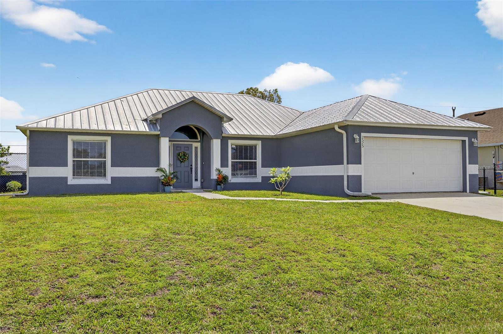 Looking for a family friendly home to make new memories? This lovingly cared-for 4-bedroom, 2-bath home, NOT IN A FLOOD ZONE, is ready to welcome a new family! Step inside and you’ll immediately love the open floor plan that isn’t your typical cookie cutter layout—it’s airy, spacious, and ideal for entertaining guests or hosting holiday gatherings. You’ll love the great natural light that pours in, making every room feel bright and cheerful. A beautifully RENOVATED KITCHEN with GRANITE countertops perfect for family dinners. The SPACIOUS primary bedroom feautres an UPDATED MODERN primary bathroom with MARBLE countertops, DUAL SINKS, SOAKING TUB and SHOWER. No carpet here—just easy-care flooring that keeps life simple and clean. Outside, the fenced backyard offers a safe spot for kids and pets to play, while the screened patio and paved area seamlessly extends your living space for BBQs, birthday parties, or peaceful mornings with coffee watching the sunrise. Enjoy your very own fruit trees and moringa tree—a sweet touch from the family that has cherished this home. The NEWER METAL ROOF that offers longer lifespan and more durable protection from storms. The current owners have NOT experienced any well depth issues during their many years here. Move in and start making memories right away!