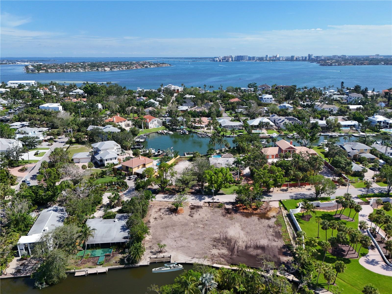 Boating access and large lot opportunity. This rare 22,671 SF (.52 acres) lot on Siesta Key offers a unique opportunity to build your dream home in one of the most sought-after areas. Fit up to a 42-foot boat on the private dock, and boat off the canal into Roberts Bay. There is 170 ft of waterfront to enjoy. This property is a short drive past the north bridge, in a mature and developed luxe neighborhood on Bay Island.
With the world-renowned Siesta Key Beach easily accessible and the convenience of the North Bridge within only a few minutes, this location offers both privacy and quick access to Southside Village, Downtown Sarasota, and all the attractions the area has to enjoy.
The lot has already been cleared and prepped for development, making it primed for your vision. Initial investments have been made, including storm debris clearing, house demolition, tree mitigation, and securing all the necessary permits.
The current developer is available to present existing plans for an elevated single-story residence or a two-story residence, should you prefer to modify the design. This is a truly rare opportunity to create a custom home in an unbeatable location!
