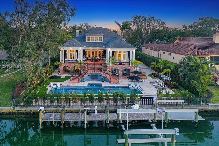 Waterfront Luxury Home in Sarasota’s Prestigious Bay Point! This waterfront luxury home on coveted Bay Point Drive offers the perfect blend of timeless Georgian Colonial architecture and modern, high-end upgrades. With over 6,300 sq. ft. of high-and-dry living space, this move-in ready residence remained untouched by recent hurricanes—an exceptional advantage in a prime coastal location. Inside, the home showcases high ceilings, an open floor plan, and multiple living spaces designed for both comfort and sophistication. The grand foyer leads to a formal dining room ideal for entertaining and a classic living room perfect for quiet gatherings. The expansive great room flows seamlessly into the chef’s kitchen, featuring premium appliances, abundant counter space, and a true gourmet layout designed for everyday living and hosting.
The home offers four bedrooms, all with en-suite bathrooms, each recently updated with luxury finishes, and upgraded fixtures. A private home theater/media room provides an immersive retreat for movie nights and entertaining. The oversized primary suite is a standout, boasting a spa-like bathroom and an extraordinary walk-in closet with room for even the most extensive wardrobe. Every detail throughout the home reflects thoughtful design and elevated comfort. Car enthusiasts will appreciate the eight-car garage, offering extensive room for collectors, storage, or creative hobbies. Outdoors, the property embraces its waterfront setting along the picturesque Hudson Bayou. Enjoy breathtaking water views, enhanced by lush, refreshed landscaping and the iconic Selby Gardens as your backdrop. This is truly a boater’s paradise, offering direct deep-water access to Sarasota Bay in under two minutes via a private dock with a 27,000 lb lift (removable for a 70’ shallow-draft boat), 4’ depth at mean low water, and approximately 6' in the channel. The manicured landscape, shaded seating areas, and expansive terraces create a resort-style outdoor living experience perfect for both everyday relaxation and unforgettable events. This enchanting property has hosted weddings, milestone celebrations, and family gatherings—all framed by the natural beauty of the bayou.
Situated between Harbor Acres and Downtown Sarasota, the home offers unmatched convenience—just minutes from world-class beaches, dining, shopping, marinas, parks, and cultural attractions. More than a home, this is a legacy waterfront estate where luxury, lifestyle, and location come together in the most extraordinary way. Welcome to Bay Point!