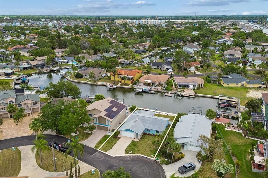 Welcome to waterfront living in the sought-after Gulf Harbors Woodlands community of New Port Richey. This beautifully remodeled, move-in ready three-bedroom, two-bath, two-car garage home offers approximately 1,611 square feet of thoughtfully designed space, filled with natural light and complemented by soft gray tones and light cabinetry for a clean, modern look. Major updates include a new air conditioner (2024), water heater (2019) and roof (2019). Enter an open, airy layout where water views immediately draw your attention and living spaces flow effortlessly together. Sliding glass doors lead to a spacious covered and screened patio, creating a setting for relaxing or entertaining while enjoying Florida’s year-round outdoor lifestyle. On a canal with quick access to the inlet, Anclote Key and the open Gulf within minutes, this home is ideal for those who appreciate boating and waterfront living. Enjoy peaceful views and the calming presence of the water right from your backyard. Inside, you’ll find a cozy wood-burning fireplace, interior laundry, and a functional floor plan designed for everyday comfort and entertaining. The kitchen is light and inviting, featuring granite countertops, light cabinetry and generous storage space. Whether you’re searching for a primary residence, seasonal getaway or an investment opportunity, this property offers outstanding versatility. Its waterfront location and desirable community make it an excellent option for personal enjoyment and long-term value. Gulf Harbors Woodlands is known for its friendly, golf-cart-friendly streets and relaxed coastal lifestyle. Just a short distance from the home, residents enjoy access to a community clubhouse and pool. Nearby, the private Gulf Harbors Yacht Club, accepting new members, offers dining, boating events and social gatherings. The community also features a private beach club with cabanas, showers, grills and restrooms, giving you ability to enjoy Florida waterfront living without leaving the neighborhood. With activities and events throughout the year, this is a community that brings neighbors together and enhances everyday living.