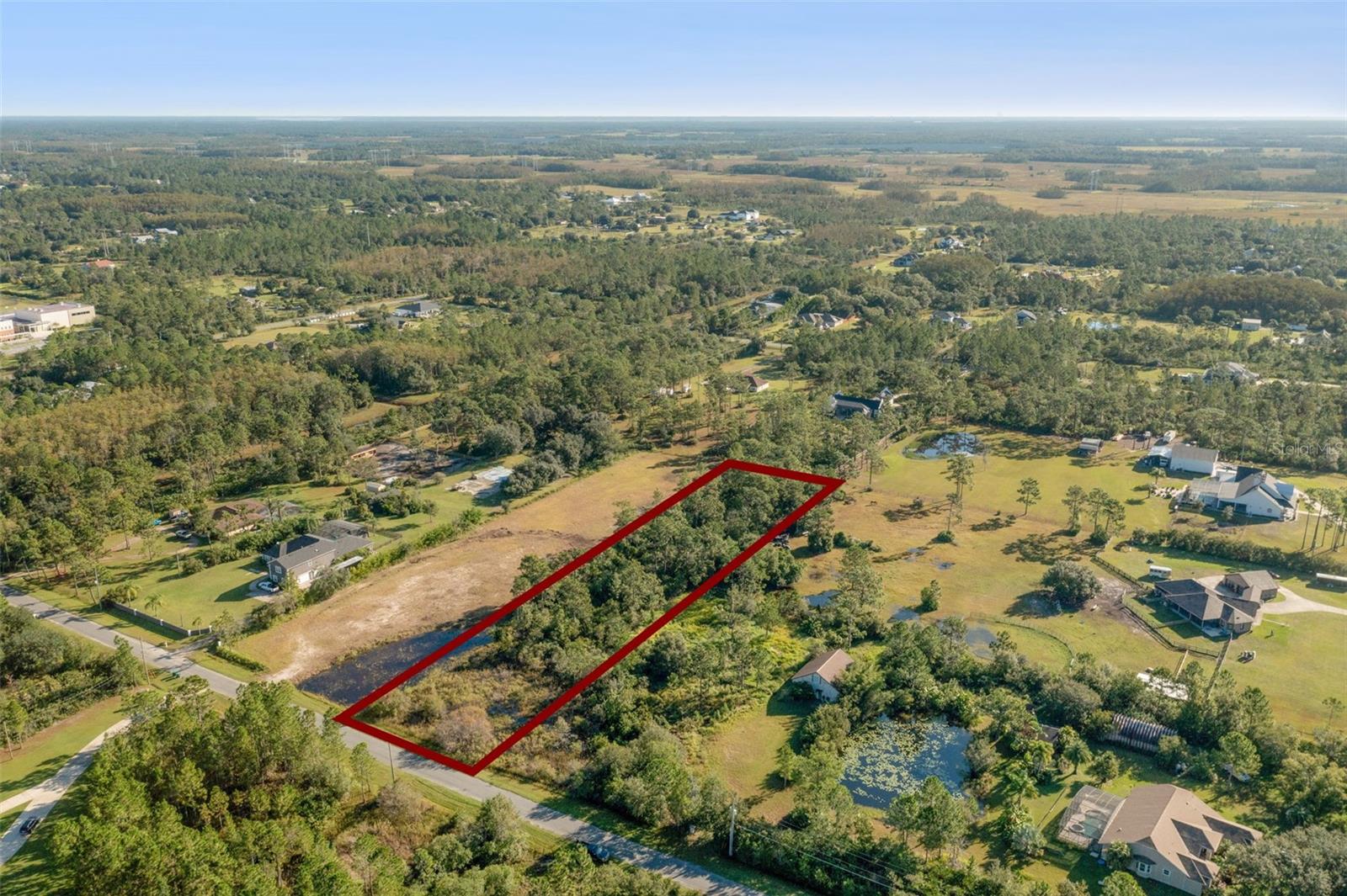 Tucked between the energy of Orlando and the laid-back pace of Florida’s east coast, this expansive 1.52-acre parcel is located in the highly sought-after community of Wedgefield, offering the best of both worlds—tranquil living with easy access to big-city conveniences. The A-2-zoned lot, measuring 105 feet wide by 629 feet deep, provides plenty of room to design your private retreat or next investment project. With electricity, cable, and high-speed internet available, plus space for a well and septic system, the essentials are already in place for a seamless build. Surrounded by lush scenery and minutes from major highways, theme parks, and the Space Coast’s beaches, this property invites a lifestyle where nature and opportunity meet.