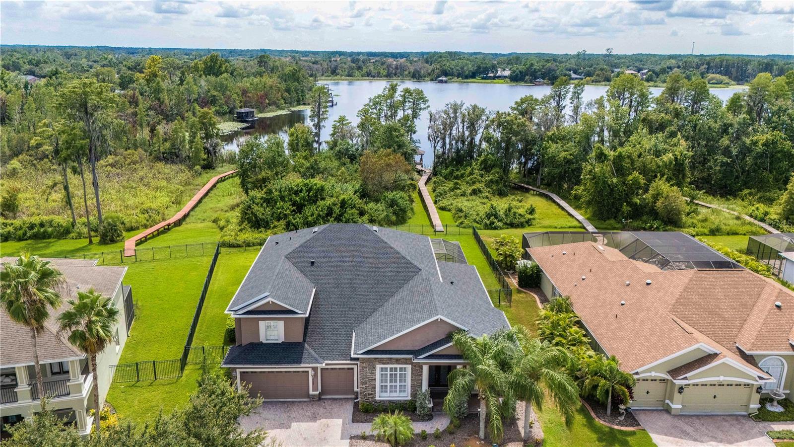 Lakefront Luxury with Private Dock in One of Land O’ Lakes’ Most Sought-After Communities
Welcome to your dream home in the exclusive Wilderness Lake Preserve, where luxury, space, and nature come together in perfect harmony. Nestled on a rare lakefront lot with your own private covered dock, this stunning custom-built residence offers the ultimate Florida lifestyle—complete with water views, peaceful conservation surroundings, and resort-style community amenities just steps away.
Designed for those who love to entertain and relax in style, this 4,375 sq ft home features 5 bedrooms, 4 full baths, a private office, formal living and dining rooms, a breakfast nook overlooking the pool, a spacious family room, a media room, loft, and bonus room—providing space for every member of the household to work, play, and recharge.
Outdoors, you’ll enjoy the best of Florida living with a screened pool and spa, covered lanai, balcony with elevated lake views, and your private dock with electricity and water, ideal for paddleboarding, fishing, or simply watching the sunset with a glass of wine in hand.
Inside, the home exudes elegance and craftsmanship with architectural ceiling details, engineered hardwood floors, plantation shutters, surround sound wiring, and a chef’s kitchen featuring marble countertops, double ovens, stainless appliances (2023) including wine fridge, and 42” cabinetry.
The primary suite is a true retreat with spa-like features, and each bedroom is generously sized for growing families or overnight guests. A spacious laundry room with upper and lower cabinetry and laundry tub keeps things tidy and functional.
Located in a gated village within walking distance to Wilderness Lake Lodge, residents enjoy exclusive access to world-class amenities: lakeside clubhouse, two pools, hot tub, sauna, steam room, fitness center, community dock, splash zone, movie theater, tennis, pickleball, basketball, nature trails, and year-round community events.
Zoned for Land O’ Lakes High School’s IB program, this home is ideal for families who value top-rated education. With recent upgrades including a new roof (2022), three new A/C units (2019), new pool equipment (2019), new ductwork (2025), and water heater (2018), this home is ready for its next chapter.
Perfectly positioned near Publix, shops, restaurants, hospitals, the Tampa Premium Outlets, and I-75 for easy access to downtown Tampa and the airport—this is truly a rare opportunity to own one of the few private lakefront homes with a dock in all of Land O’ Lakes.
Don’t miss your chance to live in a million-dollar lakefront retreat designed for elevated living. Schedule your private tour today.
