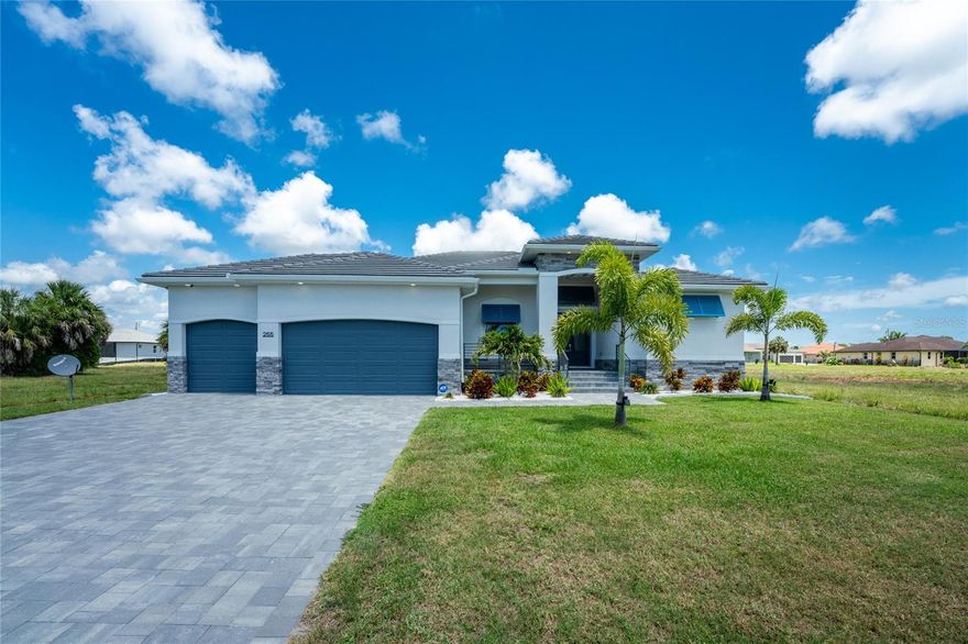 Built in 2025 and already elevated far beyond what you’ll find in most new construction, this three bedroom plus office/den/4th bedroom, three bathroom, three car garage pool home delivers a level of finish and detail that stands out from the moment you arrive. Gorgeous curb appeal with a paver driveway, stone accents, blue Bahama shutters, a tile roof, and a double etched glass door entry sets the stage for what’s inside. A welcoming foyer with a built-in custom bench and plank feature walls leads you into the open great room, where soaring 11 foot tray ceilings with crown molding and a stunning fireplace wall with built-in cabinetry add character. A quadruple set of sliding glass doors opens wide, expanding your living space and making entertaining effortless. Right off the living area, the kitchen features a large island made for gathering, custom white shaker style cabinetry with several glass front accents, quartz countertops, a designer tile backsplash, beverage refrigerator, and a walk-in pantry that is already fully outfitted with custom shelving. The adjoining formal dining space creates an inviting setting for both everyday meals and special occasions. The primary suite offers a spacious layout, tray ceiling with crown molding, and direct access to the pool through sliding glass doors. Dual walk-in closets provide ample storage, while the bathroom feels spa-like with double quartz topped vanities, a separate makeup vanity, custom finishes, and a Roman style walk-through shower complete with multiple showerheads and a built-in bench. The guest bedrooms are thoughtfully designed with privacy in mind. One bedroom features its own ensuite bathroom that also serves as a convenient pool bath, complete with a walk-in closet, walk-in shower, quartz topped vanity, and sliding glass doors. The additional bedrooms offer comfortable space and easy access to a well-appointed guest bathroom with dual quartz topped vanity and walk-in shower. The laundry room continues with nice upgrades including built-in shelving, additional storage, and a built-in utility sink with quartz countertop. Outside, the lanai and saltwater heated pool area are where this home truly shines. A spacious, partially covered lanai features hurricane resistant sunshade blinds and ceiling fans to keep the space comfortable year round. The irrigation system helps maintain the lush landscaping. What truly sets this home apart is the level of protection and peace of mind already in place. With impact windows, shutters, and additional storm-ready features, the home is designed to keep you secure when weather moves in. A monitored security system adds confidence whether you are home full-time or away for extended periods. The three car garage features epoxy flooring, high ceilings, and additional storage, giving you flexibility. Beyond the home itself, Rotonda West offers a lifestyle that is hard to beat, with multiple golf courses, miles of canals, lakes, pickleball, parks, and a peaceful setting. Just minutes away, Englewood brings you to some of the area’s best Gulf beaches, waterfront dining, local shops, and a laid back atmosphere so every day feels like you’re on vacation. Offered with the option to purchase furnishings makes this a truly move-in ready home. If you’ve been searching for a home that feels complete the moment you walk in, you’ll find it here at 255 Rotonda Blvd S in Rotonda West.