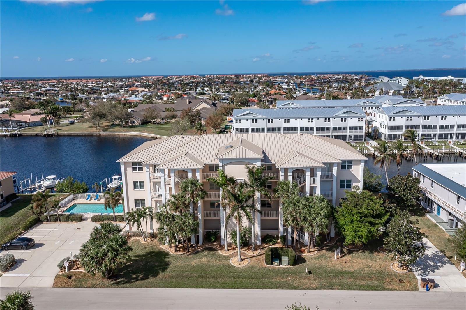 SPACIOUS WATERFRONT CONDO IN PGI W/DEEDED DOCK & QUICK BOATING ACCESS TO CHARLOTTE HARBOR! This condo at Captain's Landing in Punta Gorda Isles has it all: a great location, deeded dock, canal basin view & quick boating access to Charlotte Harbor. The unit boasts a great room layout w/over 2,000 sq ft of living space, two large bedrooms, den w/French doors, beautiful wood floors, high ceilings, eat-in kitchen & adjacent formal dining area. Large windows & a wall of sliding glass doors provide lots of natural light. Great room opens to the screened lanai extending the living space outside. Lanai has tile flooring & built-in bar w/beverage fridge all overlooking the canal basin & docks below. Grab your favorite beverage & enjoy fabulous sunsets over the canal every night thanks to the western rear exposure. The kitchen has solid surface counters, raised-panel cabinetry + decorative display shelves at end of cabinets. The master suite has a large, picture window overlooking the canal, an oversized, walk-in closet & large master bath. Master bath has dual sinks, seated vanity & glass-block shower. The guest room also features an oversized, walk-in closet. The unit has lots of storage space in addition to the large walk-in closets, there is a linen closet in the guest bath, a coat closet in the foyer & a large storage area off the laundry room plus an assigned storage room in garage. 3rd bedroom features double French doors & can easily be converted to an office/den, if desired. Unit comes w/deeded dock #5. Dock has 10,000 lb boat lift + water & electric hook-ups available dockside. Enjoy some of the best fishing & boating directly from your backyard. Other amenities include a heated pool & covered, under building parking. Deeded parking space #5 & storage space #5 come w/the unit. Take advantage of the fabulous location - miles of sidewalk connect you to Fishermen's Village, Isles Yacht Club, Gilchrist Park, Hounds on Henry dog park & historic downtown. Come discover why Punta Gorda is considered a hidden gem in SW Florida.