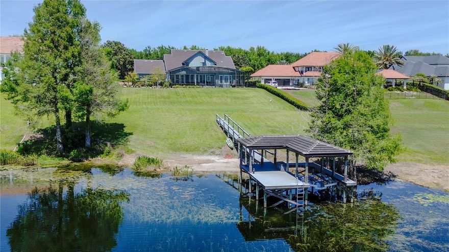 Set within the private gates of Weatherstone on Lake Olivia, this stunning lakefront residence offers a rare opportunity to enjoy refined living along the peaceful shoreline of Lake Olivia in Windermere. Situated on an expansive lakefront homesite, an increasingly rare find in this area, the property provides exceptional space, privacy, and unobstructed water views.
Boasting 6 bedrooms and 4 full baths, the home blends classic design with thoughtful updates and an inviting, functional layout.
A charming wraparound front porch creates a warm first impression, surrounded by mature landscaping and tranquil views, perfect for relaxing mornings or unwinding at the end of the day. Inside, natural light fills the home, highlighting soaring ceilings, rich wood flooring, plantation shutters, crown molding, and carefully curated designer details. The open concept design allows for effortless flow between the main living spaces, many of which capture picturesque lake views.
At the center of the home, the updated kitchen serves as a true gathering place, featuring generous prep space, a large island, stainless steel appliances, and a spacious dining area. Two oversized walk in pantries, one with a concealed bar, offer both convenience and a touch of character.
The primary suite is located on the first floor, offering serene lake views, a spacious custom closet, and a beautifully redesigned bathroom with dual quartz vanities, a soaking tub, and a walk in shower. The first floor also includes a private office with custom built ins, an additional family room, or optional formal dining space, and a full bath.
Upstairs, a well planned layout provides flexibility and privacy with five secondary bedrooms, some connected by updated Jack and Jill baths, plus a dedicated workspace with built in features on the landing area. An additional oversized bonus room with closet can easily function as a media room or play space. The home previously had a large loft area which could quite easily be converted back. 
Additional highlights include a first floor laundry room, abundant storage throughout, an updated tile roof, refreshed exterior paint, and a three car garage with epoxy flooring and built in storage.
Designed for entertaining, the outdoor living space features a covered lanai, summer kitchen, resort style pool, fire pit, artificial turf dog run, and a Trex dock with boat lift, all overlooking the calm waters of Lake Olivia, where you can water ski, have fun on your boat or jet ski's or just enjoy a calm ride on your paddle boards, the fun is endless. 
With only 13 homes, Weatherstone Ct offers a boutique gated setting just moments from local favorites like The Yellow Dog Eats, parks, top rated schools, and the heart of Windermere. This is lakefront living at its finest, private, spacious, and beautifully appointed. Ideally located with direct access to all the major highways, the home provides seamless connectivity to destinations throughout Central Florida and beyond, while still maintaining a quiet, tucked-away feel.