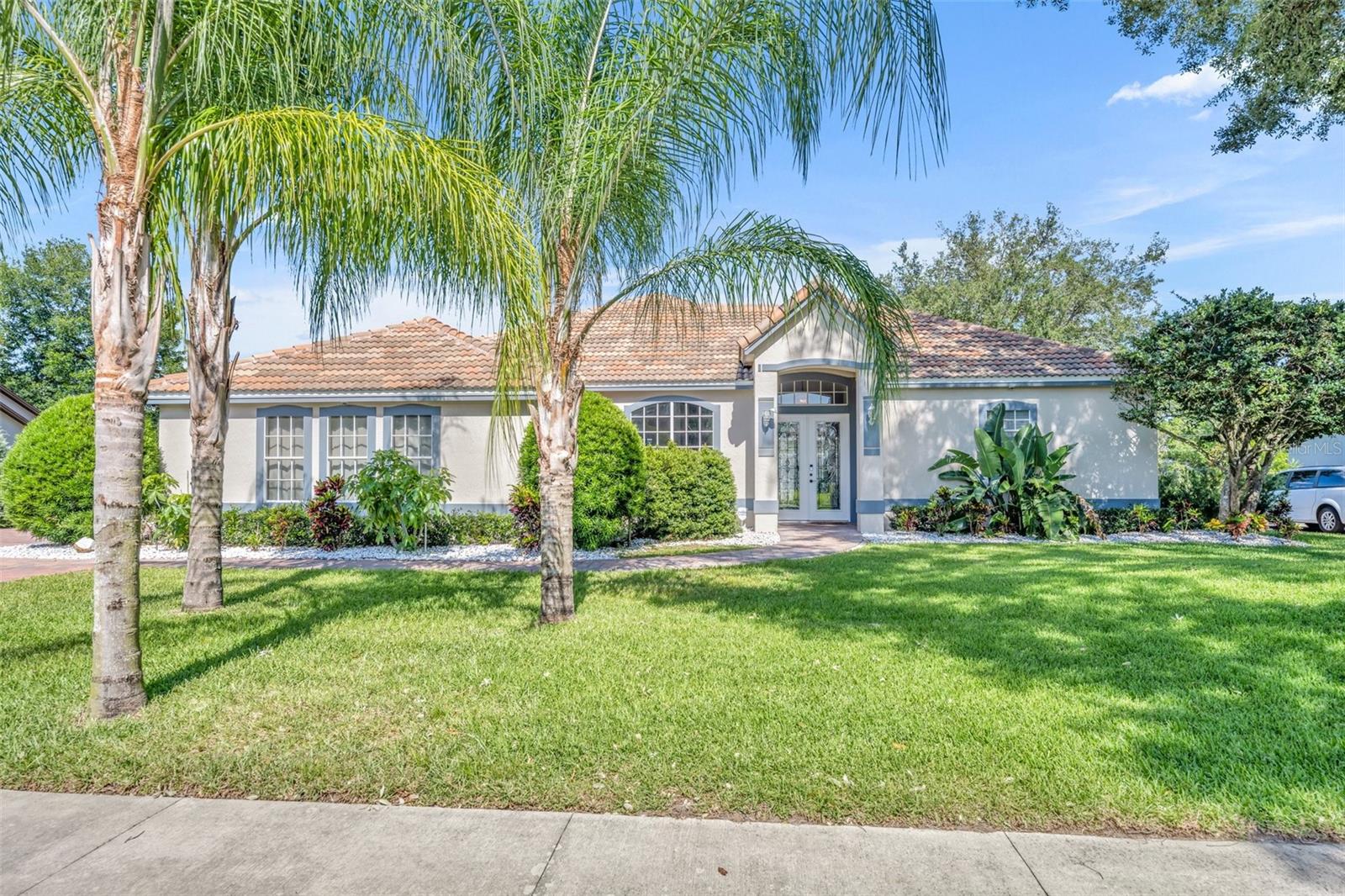 Welcome to the gated Sweetwater Greens community in Sweetwater Country Club. It is not often that the opportunity comes along to own your own home in this cozy, smaller subdivision located in this well established and sought after area of Apopka. Don't miss this one! Soaring ceilings, cathedrals, vaults in the common areas, and a custom tray in the Master Suite make this four bedroom, three bathroom mini estate a larger than life experience! Trek across a marble floor as you enter the double front door and turn right to explore the master suite overlooking the huge lanai and pool deck. The included, strategically placed cameras display real time property surveillance on the large screen TV, mounted in the master bedroom and is one of three large screen TVs included with the home. The formal living, formal dining, and the family room with its fireplace provide abundant room for whatever the special occasion may be. The huge kitchen provide plenty of room and equipment to do as the occasion demands as they congregate at everyone home space gathering place. Bedroom two is an ensuite and shares its bathroom with pool guests and provides a step in tub. Bedroom three provides a walk in closet and shares a Jack and Jill bathroom with bedroom four. Abundant natural light, the large inside laundry room with its sink and generous upright cabinet space round out the interior. Through the exit door to the garage you step into foyer area of the garage, adjacent to a huge storage room and of course, the over-size two car garage. The paver driveway and walkway add to the beauty of the curb appeal with the attractive, mature, professional landscape design. Out back is the huge pool deck covered by the huge screen enclosure to provide a private leisure lifestyle setting at your home. Up top, there is the two year old tile roof that adds a look of luxury. Enough said, schedule to see it in person today!