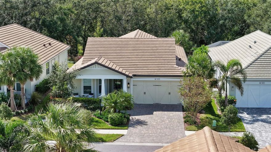 Enjoy maintenance-free living in Waterside’s LakeHouse Cove with this beautifully designed home showcasing the Cay floor plan by Homes by Towne. Positioned with southern exposure and abundant natural light, the residence features three bedrooms, two-and-a-half baths, and a spacious 12 × 10 flex room, all centered around an open concept highlighted by a soaring vaulted ceiling and expansive dining area. Sliding glass doors lead to a screened-in lanai with an outdoor kitchen, offering a serene backdrop of preserve views and exceptional privacy. The kitchen is equipped with stainless steel appliances, a breakfast bar, and a generous walk-in pantry, while throughout the home you’ll find quartz countertops, soft-close cabinetry, 24 × 24 tile flooring with no carpeting, plantation shutters, and custom woodwork that lends warmth and character. The split-bedroom design ensures privacy for the primary suite, where cove lighting accents the tray ceiling and the spa-like bath features a frameless glass walk-in shower, dual vanities, private water closet, linen closet, and dressing room. Additional highlights include a designer lighting collection, tile roof, inviting front porch, tankless water heater, and oversized laundry room with utility sink and cabinetry. Residents enjoy close proximity to Waterside Place and access to the Lakehouse Cove amenities center, which offers a resort-style pool, state-of-the-art fitness center, modern clubhouse, pickleball and bocce courts, lakefront fire pit and event lawn, kayak launch and storage, dog parks, and an active calendar of social events curated by a dedicated lifestyle director. All of this within Lakewood Ranch—the nation’s best-selling master-planned community.