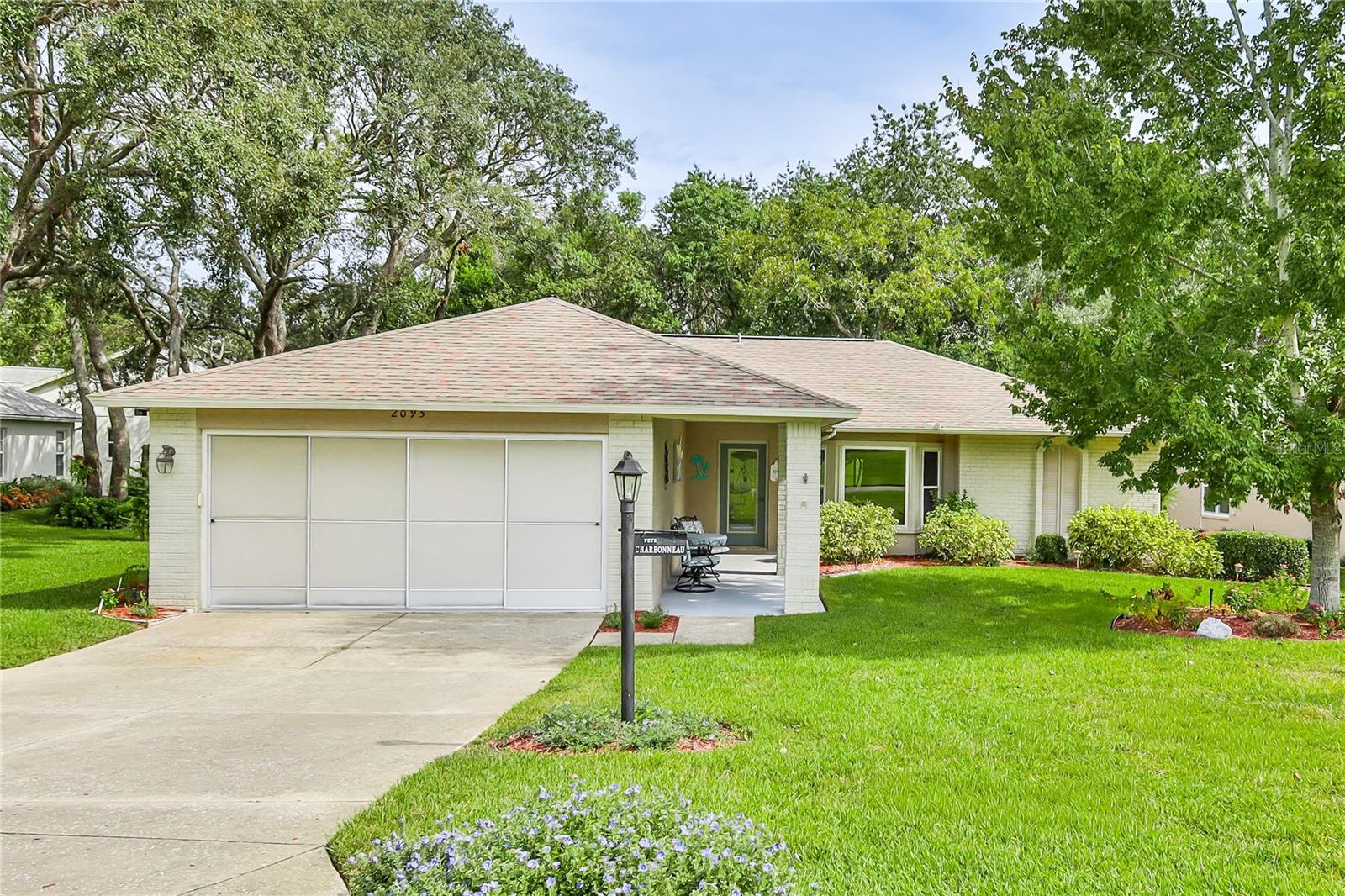 Welcome to this charming 2-bedroom, 2-bathroom home, with views of hole #5 on the Grand Pines golf course, featuring a desirable split floor plan and plenty of living space. Step into the living and dining room combination that creates a warm and inviting entry. The home also offers a spacious enclosed lanai perfect as a family room, office, or flex space. The primary suite includes sliding glass doors to the lanai, two walk-in closets, and an en suite bathroom with dual vanity sinks, modern lighting, walk-in shower, and upgraded tile. The guest bedroom also has a large walk-in closet and is conveniently located near the full guest bath. The kitchen features vaulted ceilings, stainless steel appliances, abundant cabinet storage, two pantry closets, and a cozy bay window dining area with views of the lush garden and golf course. The family room off the kitchen makes entertaining easy. Outdoor living is a delight with a paver patio overlooking the lush gardens and golf course views. Additional highlights include an indoor laundry room with sink, cabinets, and storage closet, plus a 2-car garage with workbench and shelving. Roof 2012. Windows 2019. HVAC 2021. Sprinklers on well. This home combines charm, functionality, and a beautiful setting—ready for its new owners to enjoy!
