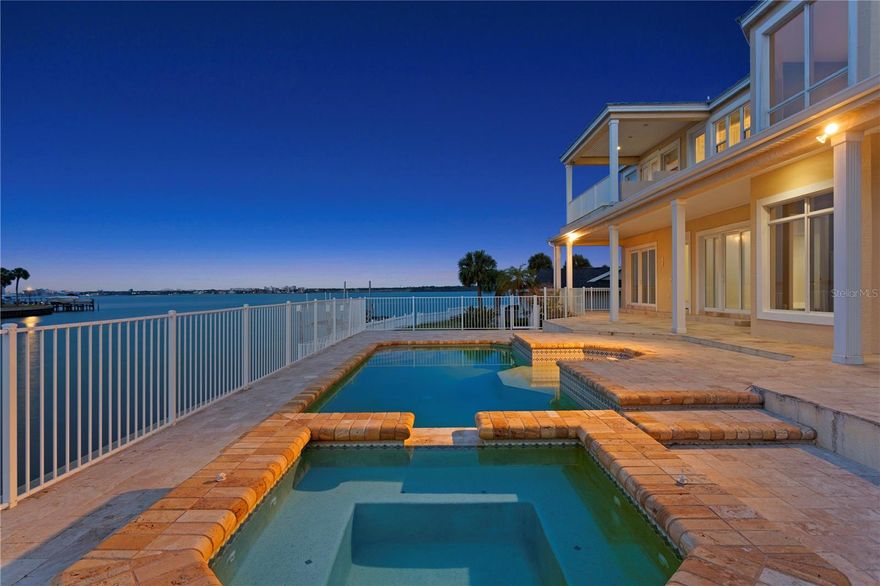 One or more photo(s) has been virtually staged. Experience waterfront living with wide Intracoastal views, ideally positioned on a quiet cul-de-sac within Biltmore Isle in Belleair Beach. Featuring 105 feet of waterfront on a 12,000+ square foot lot, the property offers privacy, space, and direct water access.
Step inside to a dramatic two-story foyer with soaring ceilings and immediate water views, creating an impressive first impression. With over 5,000 square feet of living space, this block construction residence offers a traditional layout with a comfortable, functional flow.
Multiple living areas include a formal living room and a spacious main living area with a fireplace and built-in entertainment center. The kitchen is thoughtfully designed with granite countertops, stainless steel appliances, a center island, and a walk-in pantry, complemented by both casual and formal dining areas.
On the main level, two bedrooms share a Jack-and-Jill bathroom. An additional full bath with direct access to the outdoor living area is ideal for pool use. A separate room on this level offers flexibility for a home office, gym, or additional living space.
Upstairs, the owner’s suite is a true retreat, featuring water views, a sitting area, walk-in closet, and a covered balcony overlooking the Intracoastal. The en-suite bath includes dual vanities, a jetted tub, and a walk-in steam shower. Additional bedrooms include a private suite with its own en-suite bath and balcony, as well as another bedroom with a loft-style studio area, ideal for a game room, creative space, or lounge, also complemented by its own en-suite bath.
Outdoor living is designed for relaxation and entertaining, featuring a covered deck with multiple seating areas, a pool and spa with a sun deck, and a composite dock and seawall providing direct water access. Additional highlights include a circular paver driveway, garage workshop and storage space, and epoxy flooring.
The property offers exceptional outdoor space and the opportunity to enjoy both sunrise and sunset from different areas, with the Gulf beaches just a short walk away. The residence is elevated, adding an extra layer of peace of mind. A rare opportunity to own a waterfront home in Belleair Beach.