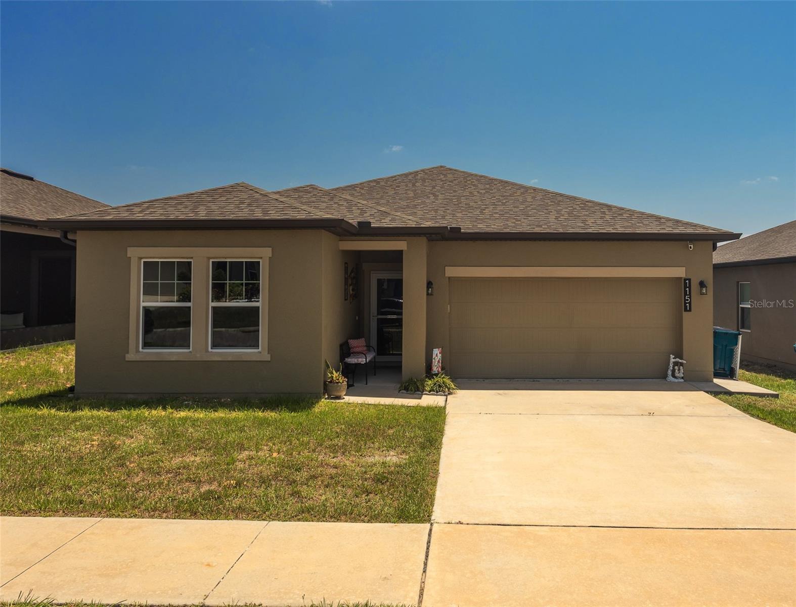 MOTIVATED SELLER – Single Owner! This beautifully maintained 3-bedroom, 2-bathroom home offers 1,779 sq ft of move-in ready living space in a highly desirable location. Designed with a functional split floor plan, the home features updated vinyl seamless flooring and smoke-tinted windows for enhanced privacy and energy efficiency. The kitchen opens seamlessly into the main living area, showcasing large granite countertops, stainless steel appliances, and coordinated pendant lighting that adds a modern, cohesive touch to the kitchen and dining space. A dedicated laundry room with washer/dryer hookups makes chores convenient and organized. The spacious primary suite includes a generous walk-in closet and a stylish master bath with distinctive barn doors. Additional bedrooms provide ample storage, perfect for guests, family, or home office needs. Step outside to enjoy the screened-in veranda and extended lanai—ideal for relaxing or entertaining. The fenced backyard and seamless rain gutters add to the home's practicality and curb appeal. The attached 2-car garage features durable epoxy flooring and attic access for extra storage. Located in a sought-after, walkable community with top-tier amenities including a resort-style pool, dog park, playground, and more, this home offers the perfect blend of comfort, style, and functionality. Located in the heart of growing Davenport, close to shopping centers and theme parks. This is a must see!