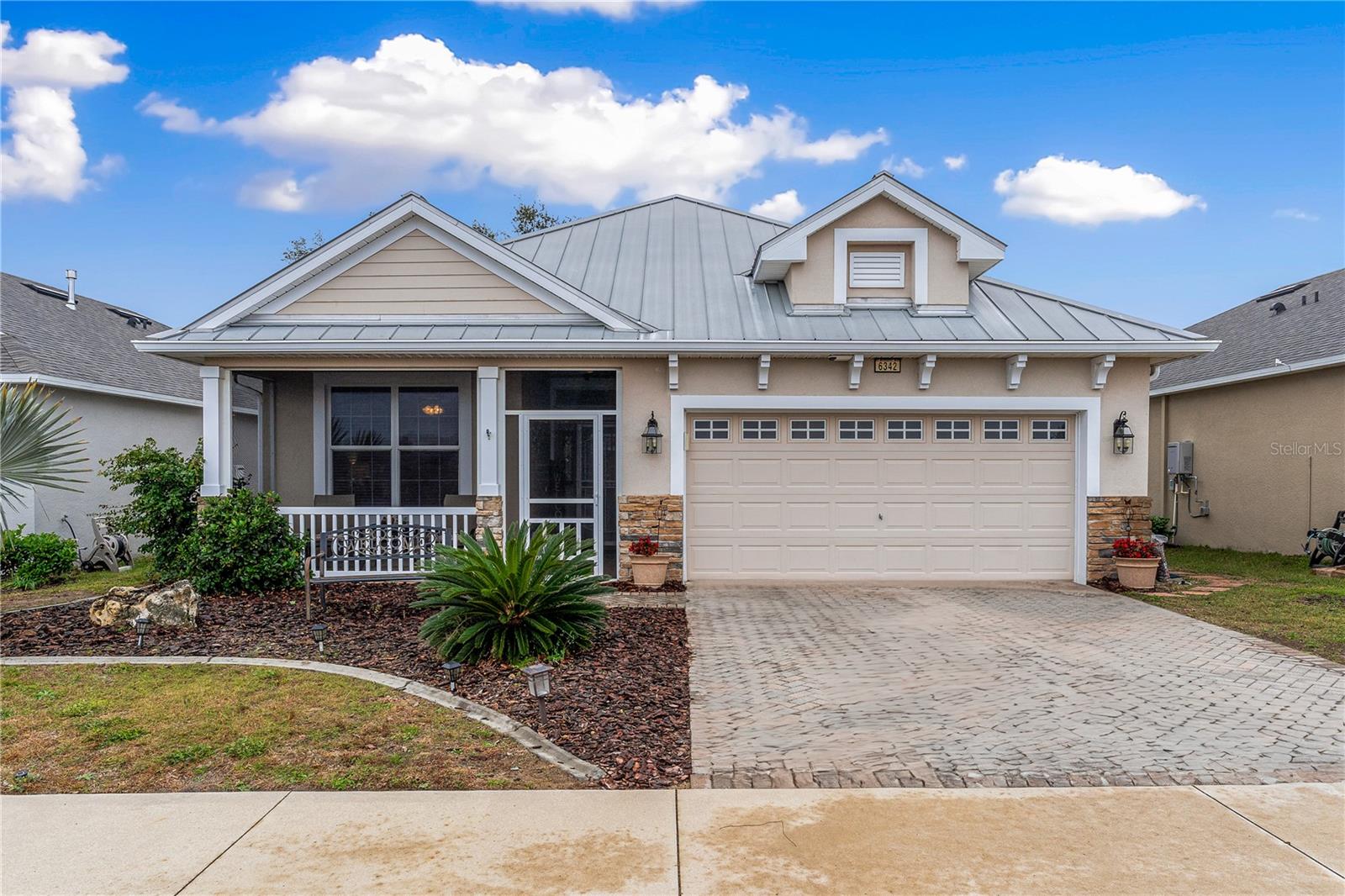 Welcome to The Cottages of Sanders Grove, a 55+ community just outside Leesburg and close to The Villages. This home features an open floor plan with high ceilings, tile flooring in the living areas, and carpeted bedrooms. The spacious kitchen boasts Corian countertops, a breakfast nook, a closet pantry, and newer stainless steel appliances. Two sets of French doors lead to a large screened lanai. The master suite includes his & her closets, double vanities, a walk-in shower, and a private water closet. Two additional bedrooms share a bathroom with a tub/shower. Enjoy natural light from two solar light tubes, plus energy efficiency with a tankless water heater. The home also offers a 7x6 laundry room and a 20x19 two-car garage with an electric opener. The beautifully landscaped yard is perfect for privacy with the option to fence in the backyard. Located with easy access to the turnpike, this home offers convenience and comfort near Orlando and The Villages.