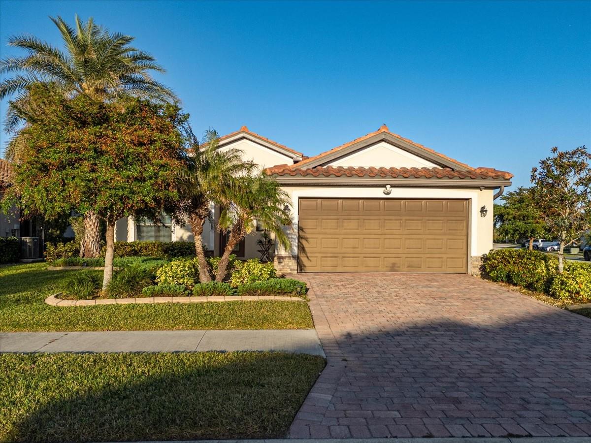 REDUCED PRICE - CHECK-OUT TIME IS WHEN? This is what you will ask yourself when living in this exquisite home in the community of Gran Paradiso. This desirable Model comes with 3 bedrooms and 2 baths, and is situated on a corner lot lot. You will not be disappointed. The welcoming front porch and Florida friendly landscaping give this home superb vibes. A step inside finds ceramic tile set on the diagonal, throughout the main living area with carpet in the bedrooms. The kitchen is decked out with stainless steel appliances, granite counter tops, and a pantry that is open to the living and dining areas. The openness of the Great Room area allows for family gatherings and entertaining with friends. Crown molding adds ambiance to the home in the main living areas and the main bedroom. The master bathroom is a true sanctuary complete with with glass shower linen closet and dual sink vanity. One additional bedrooms are at the opposite end of the home as is a second bathroom with tub/shower combo. Cabinets and a laundry tub have been added to the inside laundry area for all of your storage need. Spend leisure time on the screened lanai after a long day. Home furnishings left at buyers discretion. Gran Paradiso is a resort style community with a full-time activity director, basketball, zero entry pool, sauna, hot tub, tennis, pickle ball, playground, clubhouse, miles of walking trails, and plenty of social opportunities to meet neighbors. The location is minutes away from the Atlanta Braves Stadium, Wellen Park and the new Downtown, Gulf Beaches, shopping, and fine dining. This resort-style community is sure to impress the most discerning of buyers. Call today to make an appointment to view this impeccable home! The FLOOD Insurance Policy is assumable for this home.