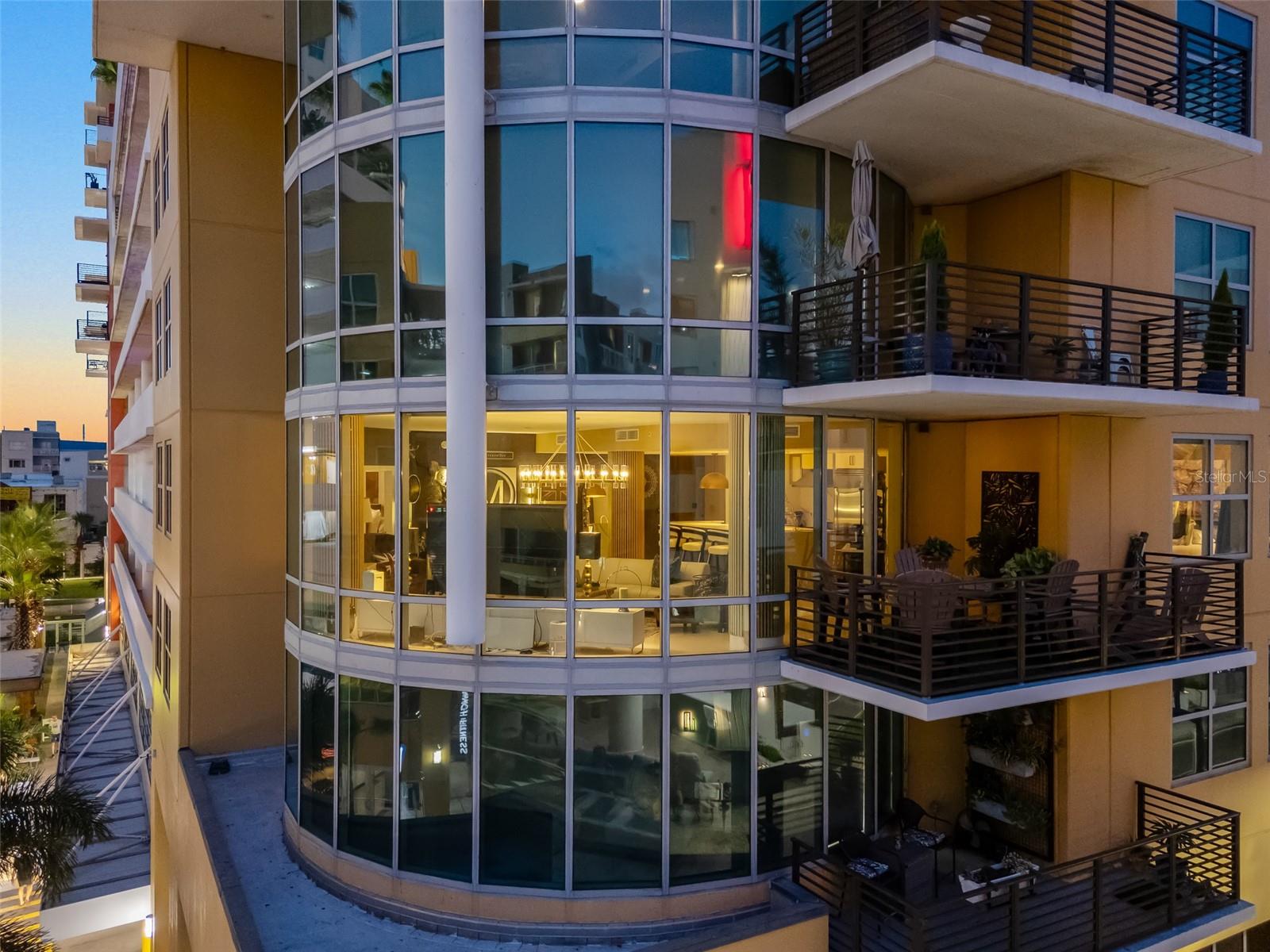Discover a one-of-a-kind urban sanctuary in the largest corner residence at Grand Central at Kennedy, positioned in downtown Tampa. This professionally designed home offers an expansive floor plan that combines stunning aesthetics with ultimate functionality. The chef’s kitchen is a masterpiece, boasting custom Wellborn cabinets, a massive quartz island with double waterfall edges, continuous quartz backsplash, and premium Viking appliances. This space flows seamlessly into the great room, where 180-degree floor-to-ceiling windows offer spectacular panoramic views flooding the interior with an abundance of natural light while being controlled effortlessly by motorized sunshades. This unique residence features a split-bedroom layout with two primary-style suites and a chic powder room for guests ensuring privacy and comfort. The primary suite is a lavish retreat with huge custom-built walk-in closets and an elevated, spa-like en-suite. The second oversized bedroom also includes a private en-suite and spacious walk-in closet with custom built-ins. Fine details are evident throughout, from the stunning Italian tile floors, custom dry bar, and upgraded fixtures. This residence also includes one of the largest private terraces in the building, finished with turf. The luxurious features extend beyond the interior, most notably, a private rooftop poolside cabana — a rare amenity with a full bath, beverage refrigerator, shower and storage. The unit also comes with two oversized parking spaces behind a secondary private gate, a large 8-by-10-foot climate-controlled storage locker, and a semi-private elevator for added security and convenience. Additional social amenities are on the first-level courtyard featuring covered outdoor social areas, Crunch Fitness, Ginger Beard Coffee, Pour House, The Poké Company, Massage Envy, Gelato-Go and Stageworks Theater. The Channelside District is adjacent to the Water Street District and desirable because of its short distance to the adjacent Publix, the Madison Street Park with pickleball courts, Starbucks, CVS, and trolley access to Port of Tampa, Ybor City, Sparkman Wharf, Amalie Arena and the Tampa Riverwalk.