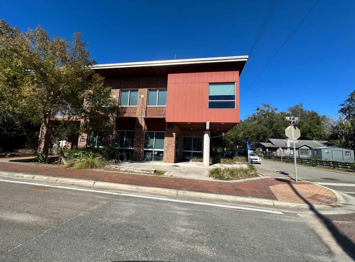 This office was constructed by the city of Gainesville as part of the ongoing plan to revitalize the historic commercial district along NW 5th Avenue from NW 13th Street to NW 6th Street. This places the property in close proximity to the University of Florida and the downtown area. The new owner is utilizing the upstairs unit but the downstairs is available for alternative use. This unit has one executive office as well as two other offices plus a large open area that is available to for a variety of uses. The building has large plate glass windows providing lots of natural light inside. There are three access doors, one of which is to the executive suite while the other two are located along NW 5th Avenue. The upstairs unit has it's own access separate from the downstairs unit so that is a plus. Additionally, the downstairs unit has it's own heating and cooling system as well as two separate bathrooms with a water fountain. There is a large storage area that has facility for printers, servers and other devices. The ceiling is acoustical tile and the flooring in mostly carpet with polished concrete in the bathroom. The property has it's own parking lot with 20 parking spaces. Keyless entrance is available for a small monthly fee and internet is relatively inexpensive with Cox (ask listing agent for details).