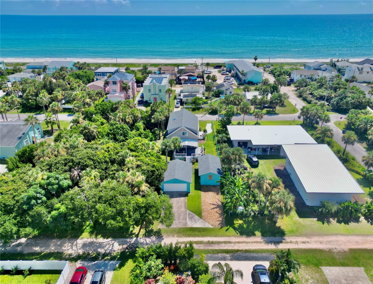 Nestled just one block from the Atlantic Ocean, this charming, well-maintained Flagler Beach home sits atop the highest dune on South Central Avenue, offering multiple ocean views and abundant natural light throughout. Featuring soaring ceilings with exposed wood beams, the main floor includes a spacious primary suite, second bedroom, full bath, large kitchen, dining area, great room, and laundry. Upstairs you'll find a third bedroom, oversized Jack-and-Jill bath with walk-in closet, and a huge studio perfect for a home office, art space, or guest area. A detached two-car garage and large separate workshop are accessed from the alley and benefit from an additional Ocean City Avenue address for convenient rear service road deliveries. Recent upgrades include a full roof replacement with moisture barrier on all three structures (Feb. 2022), new AC and air handler (July 2024), and a clean, high-producing irrigation well. Just one block from the ocean, this unique property is the perfect canvas for your dream beach house.