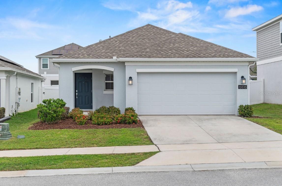 Why wait for new construction when this beautiful and like new 2023-built home with PAID AND OWNED SOLAR is ready NOW? This model offers a perfect blend of modern design and comfort, with an open and split 3-bedroom, 2-bath floor plan that suits both family living and entertaining. Step through the entry foyer to the heart of the home, where a spacious gourmet kitchen that's both stylish and functional features stunning quartz countertops, 42” cabinets, subway tile backsplash, stainless steel appliances, pantry and an enormous island with breakfast bar that opens to the bright and airy living and dining area that’s a perfect cohesive space for gathering. Elegant ceramic tile flooring runs throughout the main living areas, offering both durability and charm. Extend living space outdoors with sliding glass doors that lead from the living room to a covered patio and fully fenced in yard. The primary bedroom is located at the back of the home for added privacy with a feature board and batten wall and walk-in closet that provides ample storage. The primary bath boasts a double vanity with quartz countertops with dimmable LED anti-fog mirrors, new fixtures and spacious stand-alone tiled shower. Two additional bedrooms feature plush carpeting and share a hallway bath with a quartz vanity, dimmable LED anti-fog mirrors, new fixtures and a shower/tub combo. Throughout this freshly painted home, upgraded ceiling fans provide added comfort in every room. Additional perks include PAID AND OWNED solar as well as a washer and dryer, making this home energy efficient and completely move-in ready. Trinity Lakes offers a suburban lifestyle with easy access to major highways like US-27 and the Florida Turnpike. Residents can enjoy a balance of rural charm and proximity to the vibrant cities of Clermont and Orlando. Enjoy a variety of amenities designed to promote a comfortable and active lifestyle such as a resort style pool, fitness center, playground, walking trails, parks and recreational spaces.