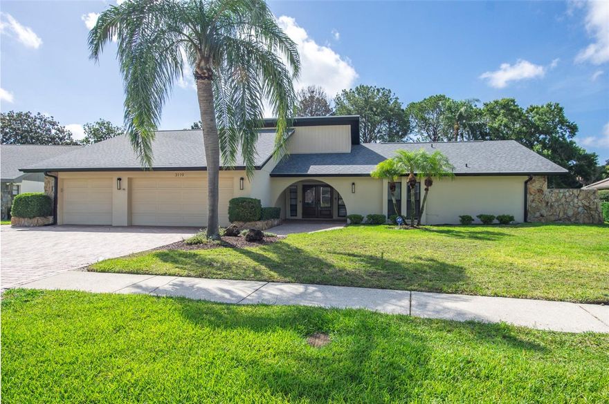 One or more photo(s) has been virtually staged. A turn-key opportunity in the heart of Countryside, Clearwater! This classic Rutenberg home is perfectly nestled on a premier 1/3-acre lot in Clubhouse Estates along the 2nd fairway of the Countryside Country Club Lake Course — and now benefits from over $275,000 in 2024–2025 owner-funded renovations that bring every major living area up to today's luxury standard.
Well-kept landscaping and a three-car paved driveway frame the curved, covered entranceway and double front doors. Step inside to an open, welcoming entryway that flows into a formal living and dining area, where sliding glass doors fill the space with light and open onto patio, pool, and golf course views — a true indoor-outdoor connection. Approximately 3,000 SF of new luxury vinyl plank flooring ties the home together with fresh, neutral elegance, complemented by new tape, texture, and paint, new baseboards and trim, and new interior doors with updated hardware throughout.
A versatile 3-way split layout accommodates a variety of living situations, offering either 4 bedrooms plus a study or a full 5-bedroom configuration. The completely reimagined primary suite anchors one end of the home, featuring a fully renovated master bath, redesigned bedroom, split vanities, a spacious dressing area, one walk-in closet — including a brand-new custom master shelving — and private sliding-door access to the pool, garden, and golf course beyond. The den / fifth bedroom is right off the primary suite completes this wing and is a perfect office or nursery. 
At the heart of the home, the kitchen is built for gatherings: ample dining space, a working island, quality wood cabinetry, neutral solid-surface Corian countertops, and a pass-through window to the lanai that makes entertaining effortless. It opens directly to the family room, complete with vaulted ceiling, a warm wood-burning fireplace, and a wet bar.
The second, third, and fourth bedrooms and two full baths complete the layout. The fourth bedroom and bath pulls additional duty as the pool bath and functions easily as an in-law or private guest suite.
Outside, a large deck surrounds the pool, with a covered lanai for comfortable seating and dining year-round. Recent sealed patio work, new exterior lighting, and tinted windows extend the refresh outdoors, and a new architectural shingle roof (2024, permitted) with a separate bitumen roof over the covered patio — plus new fascia, soffit, and gutters — delivers true peace of mind from day one.
Rounding out the property is an oversized three-car garage with workshop area, wall-mounted A/C, a secondary utility sink, abundant built-in storage, and a durable new epoxy floor.
