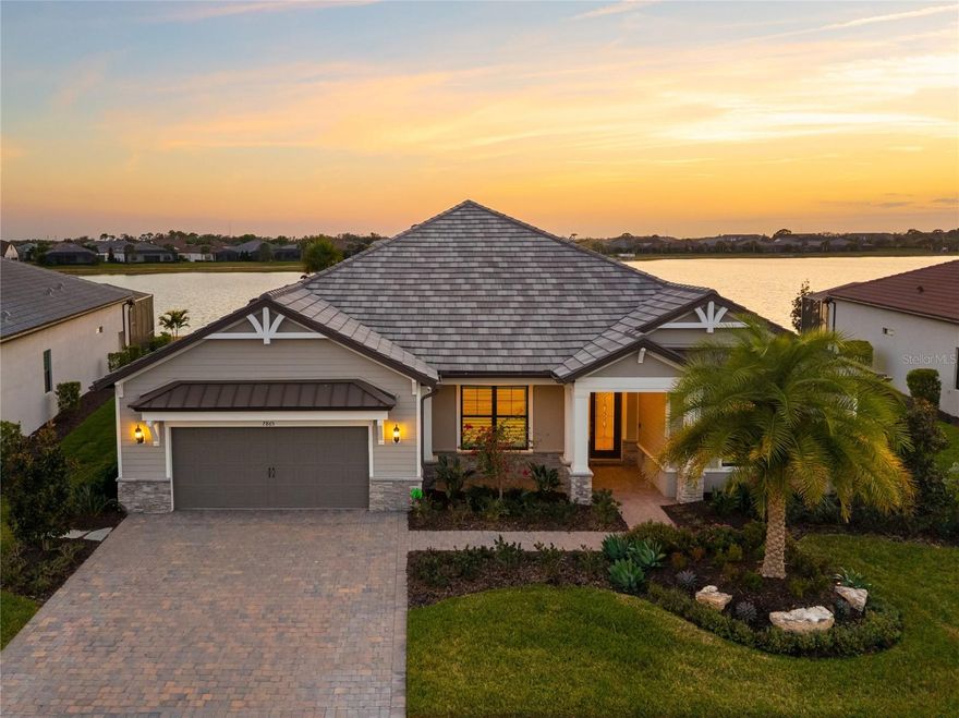 An extraordinary expression of lakeside luxury, this impeccably fully upgraded residence is perfectly positioned along one of the largest lakes in the highly sought-after community of Shoreview at Waterside.  Fully upgraded with nothing left to be desired, this home offers four bedrooms, three full baths, two half baths, and a versatile flex room all one level. Upon entering, you will be welcomed by a captivating water view and rich wood flooring that flows throughout the main living spaces.  The gourmet kitchen is expertly suited for entertaining with double ovens, quartz countertops, an oversized island with seating, reverse osmosis system, a walk-in pantry, a gas cooktop, and a custom tile backsplash.  The great room impresses with soaring ceilings and a custom built-in TV wall with fireplace. Integrated Sonos speakers throughout the home create the perfect ambiance as upgraded 10-foot sliders open seamlessly to the outdoor retreat. Unwind in the resort-style pool and spa while taking in expansive water views and coveted southwest exposure. The entertaining space continues with an extended lanai, natural stone pavers, a convenient pool bath, and a fully equipped outdoor kitchen featuring a Coyote grill, side burner, beverage refrigerator, and sink.  The owner’s retreat serves as a private sanctuary, highlighted by tray ceilings, motorized blinds, and a spacious sitting area. The adjoining primary bath offers a large soaking tub, a custom tile feature wall, and an expansive custom closet. Three separate guest suites—one with a private en-suite bath—provide comfortable accommodations for family and visitors. A dedicated flex space near the kitchen, complete with a wet bar, offers versatility and is ideal for a home office, bonus room or dining room.  This home offers added peace of mind with impact windows, a security system, and exterior cameras. The two-and-a-half-car garage features epoxy flooring, an electric vehicle charger, built-in shelving, and dedicated golf-cart parking. Additional highlights include a designer powder room with upgraded tile, built-in wine wall, enhanced landscaping, easement for a dock, a widened driveway and custom closet systems throughout.  Shoreview at Waterside Lakewood Ranch is a highly-sought-after community that features resort-style amenities such as a beach area, heated pool and spa, clubhouse, tennis and pickleball courts, and a state-of-the-art fitness center. This home is in close proximity to Waterside Place - Lakewood Ranch’s newest town center and the only waterfront retail and lifestyle destination in Sarasota. HOA includes all landscaping.