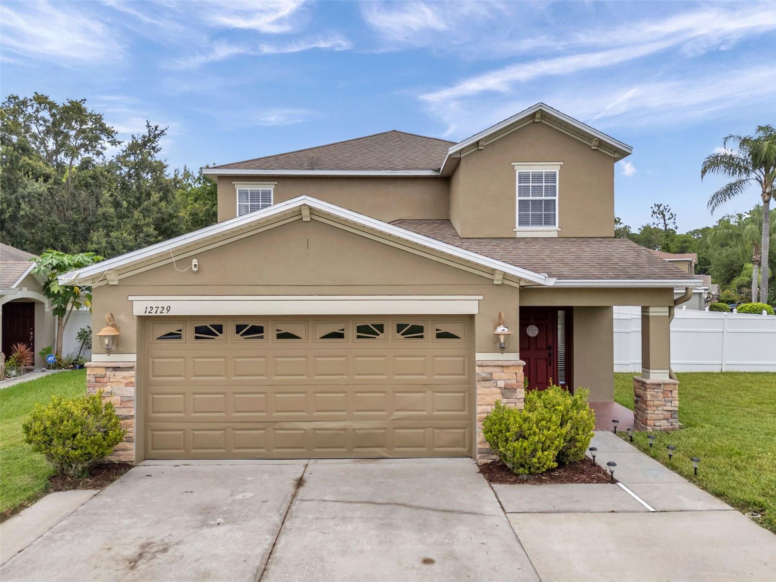 This 5 bedroom, 2 1/2 bath home with loft is located in The Verandahs. The home features a 2 car garage, large. driveway, and an oversized fully fenced corner lot. Primary bedroom is located on the first floor with it's own bathroom & a garden tub. All additional bedrooms and loft are located on the 2nd floor. Eat-in kitchen with beautiful granite countertops and sliding glass doors leading to the huge backyard. Recent updates: A/C was installed 4/22 and the whole interior has been painted and new vinyl flooring in the primary bedroom and living/dinning area. New roof will be installed prior to closing at sellers expense. This gated community offers a clubhouse, fitness center, & a beautiful swimming pool. Also you will find walking paths and a playground. Suncoast is only minutes away for a short commute to Tampa. Schedule your appointment today.