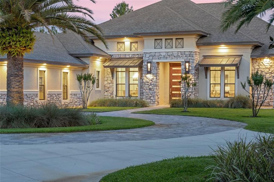 This custom built 5 Bedroom, 4.5 Bath Pool Home is in the gated equestrian community of Seminole Woods!  Seminole Woods offers 1552 acres with 252 homesites on 5 acre lots, miles of horseback trails, a private 12 acre park on skiable Buck Lake w/boat ramp, fishing dock, playground, pavilion, beach & basketball court! Bring your boats & horses! Upon arrival, there is a security gate to the large circular driveway, you will notice the custom pivot front door. The foyer opens to the living room which boasts a 72' linear electric fireplace w/ colored flame features & built-in accent shelves! The dining room has beautiful mirrored coffered ceiling.  The open layout includes the foyer, dining room, wine room, wet bar, living room, kitchen & breakfast area! The wine room holds approx. 100 bottles of wine! The wet bar has a wine fridge & plumbed for an ice maker. The gourmet kitchen is a chef's dream w/ a large center island, induction range w/ pot filler, double built-ovens, Advantium microwave, large farm sink, a closet pantry for small appliances & storage & a walk-in pantry that has an additional refrigerator! The main kitchen refrigerator is a "smart" fridge w/ 2 separate freezers.  There is a slide out shelf on the island that allows for handicap access for food prepping. The home office is just off the foyer & living room.  The master bedroom is spacious w/a sitting area that overlooks the pool & patio! There are two walk in closets w/ custom built-ins & is modified for handicap access. The master bath is a retreat that overlooks a private garden, has a large walk-in shower w/ dual shower heads, large vanity with dual sinks & makeup vanity. The bathroom also features a toilet w/ bidet and a walk-in spa tub.  The master BR has its own solar water heater. Bedrooms 2, 3 & 4 are all spacious w/ walk-in closets.  From the main living area you will find the family/media room that has 2 sets of triple sliding pocket doors that open up to pool & lanai area. Triple stacked sliding doors from the living room also lead out to the outdoor entertaining area that includes an outdoor cooking area/pool/patio/spa.  The 5th bedroom is located within the lanai, and could function as guest suite w/full bath & walk-in closet!  The pool/spa/patio/outdoor kitchen area is something to be seen costing over 200K! The salt water infinity pool (around the entire perimeter) can be heated by solar, a heat pump or propane & is controlled by a Hayward Omni Logic control system. The beautiful pebble tec finish is accented by 2 large fire bowls, 4 water features & LED lighting! The heated spa accommodates 6-8 people & is accented w/ built in lounge chairs. The cooking center features a Fire Magic gas grill, 120 BTU power burner, garbage disposal, & refrigerator. The 3 car tandem garage has a workshop, TESLA 80 amp charging station, RV hookup, attic storage.  Connecting the 2 garages is a 3 car wide porte corchere & outdoor parking space! There is a new RV parking pad next to the garage. Large laundry room w/folding counter & storage closet. Electric window shades throughout, crown molding, 10 & 12 ft. ceilings, blue tooth ceiling fans, 3 AC units, 2 septics, 2 propane tanks, whole house sound system, security system, massive attic storage w/ lights & a catwalk bridge, deep well irrigation system, ozone generator, landscape lighting, tankless water heaters. Have I mentioned the solar array system for the home - sellers electric bill runs around $100 monthly! PARADISE! Room Feature: Linen Closet In Bath (Primary Bathroom).