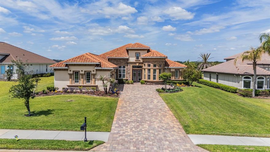 You will love this stunning home in The Bluffs, a desirable area in the prestigious Lake Jovita Golf & Country Club. On a beautiful homesite of .65 acres, this luxury estate was custom-built by ICI Homes and is an expanded version of the Egret V, a popular floorplan. Upon entering the home’s lovely foyer, you’ll notice the architectural details with 12-foot ceilings, accent trays, crown molding and beautiful flooring. The open floor plan encompasses a spacious living room, dining room, kitchen and breakfast nook in the heart of the home. The living room is showcasing a tray ceiling, neutral tones and quadruple sliders leading to the Florida room and pool lanai. The dining room is large and well suited for hosting guests. You’ll love the deluxe designer kitchen, a chef’s dream with a substantial kitchen island, ample 42-inch cabinetry, a large, hidden pantry, a coffee bar and wonderful high-end appliances, complete with a cooktop, built-in convection microwave and oven.  Soft-close doors and drawers add a level of sophistication, while the hidden pantry ensures a tidy appearance. The breakfast nook also offers generous space and overlooks the pool and backyard. Adjacent to the foyer, the home features a wonderful office or flex space with a bay window overlooking the front yard. The primary bedroom suite has added space for a sitting area and the closets were extended for added storage. The primary en-suite bath includes a garden tub, walk-in shower and dual vanities in neutral shades, creating a soothing retreat.  This split floor plan offers three guest bedrooms, two of the spacious bedrooms share a full bath, while one of these bedrooms is used as a butler pantry, which can easily be converted back into a bedroom. The third bedroom features its own en-suite bath, which also doubles as a pool bath. The Florida room adds an additional 369 square feet of air-conditioned living space. Sliders from the Florida room lead out to a beautiful, heated saltwater pool, and a spacious, paver screened-in lanai. The front and backyards feature lush tropical landscaping and are maintained with an irrigation well system. The attention to detail is evident throughout the home and property. The Lake Jovita Golf and Country Club is a semi-private, top-ranked facility that boasts two championship courses known for their elevation changes and scenic rolling hills, in addition to providing a full range of amenities, including golf, tennis, a Junior Olympic pool, fitness facilities, and casual or fine dining options. Various membership options are available. Lake Jovita’s Golf and Country Club, north of Wesley Chapel and Tampa, just east of Interstate 75, offers an elevated Florida living experience.