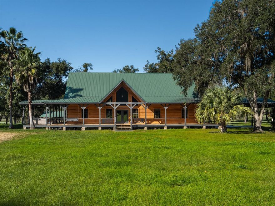 Located less than 20 minutes from the renowned World Equestrian Center, this 20-acre fully fenced estate offers an exceptional blend of functionality, beauty, and rural tranquility. Designed with equestrian pursuits in mind, the property features an impressive array of horse amenities, including an 18-stall center-aisle barn with a tack room, feed room, and washracks, a 7-stall shed-row barn, riding ring, and ample storage for hay, equipment, and supplies. A dedicated barn office provides the perfect space for managing farm operations, while a separate trailer/motor home garage ensures secure parking and additional storage capacity. The main home is a charming log residence that exudes warmth and rustic elegance. Featuring an open floor plan, 3 bedrooms, 3 full bathrooms, and soaring cathedral ceilings, the home welcomes you with an abundance of natural light and an inviting sense of space. Interiors have been freshly sanded and varnished, complemented by all-new appliances and beautifully updated windows. The exterior has also been carefully varnished and sealed for long-lasting appeal. Inside, you’ll enjoy spacious bedrooms and a striking stone fireplace, while outside, the home is enhanced by a wraparound porch nestled among mature oak trees, an ideal spot for relaxing and taking in the surrounding landscape. Adding versatility and income potential, the property also includes a fully renovated 1-bedroom, 1-bath barn apartment, perfect for guests, staff, or rental opportunities as well as an updated 3-bedroom, 2-bath mobile home. Move-in ready and thoughtfully updated, this remarkable property combines equestrian excellence with modern comforts, creating a serene retreat that is both highly functional and irresistibly inviting.