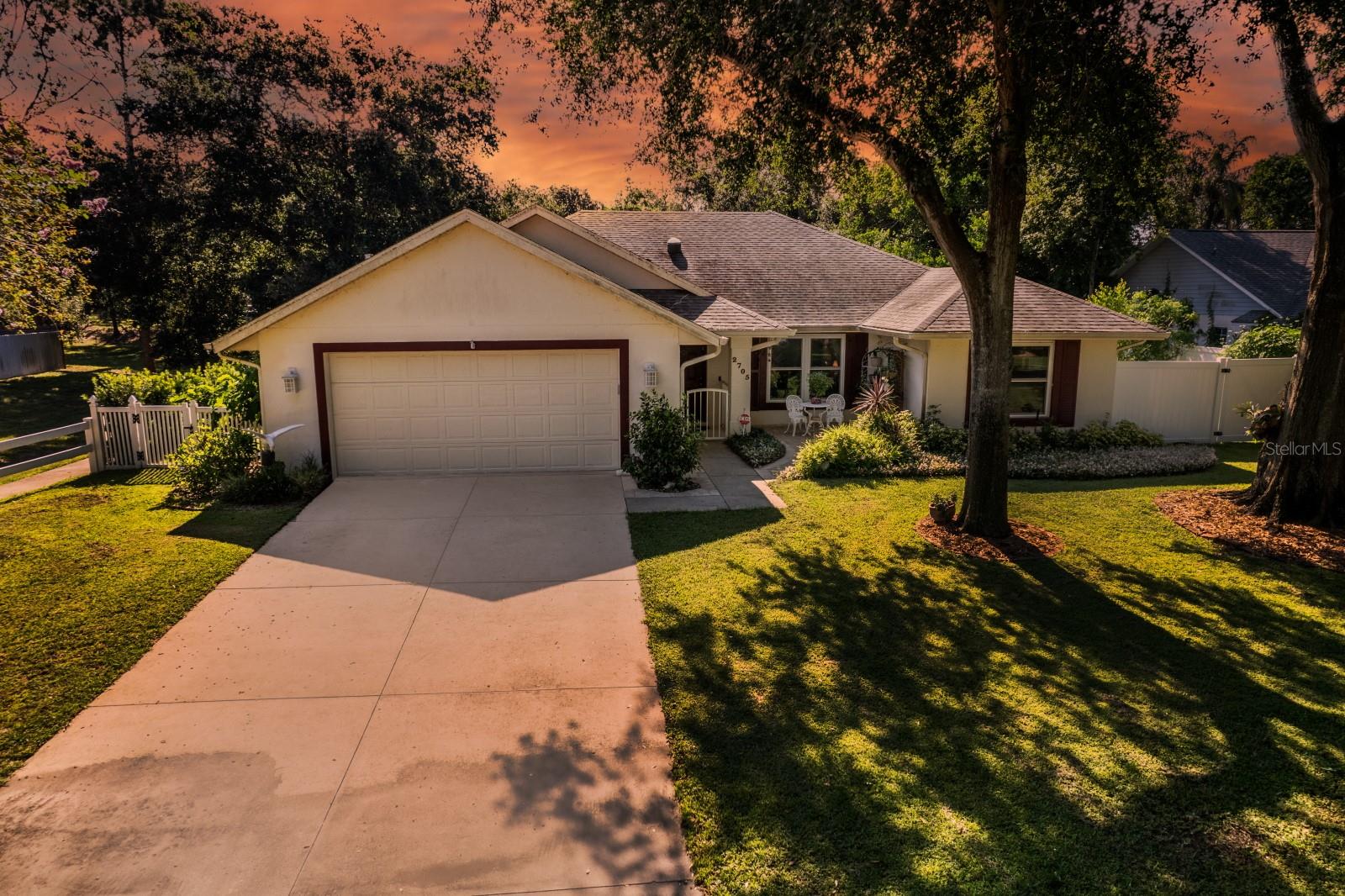 A Truly Exceptional and Beautiful Eustis home in 44 Gables. Situated in a community with quick access to Hwy 441, a main artery to neighboring towns or take State Rd 44 due East into Beaches, or Donnelly minutes into downtown Mount Dora. This location is central to lots of activity, shopping, medical centers, schools, festivals, parks, lakes, entertainment and restaurants. Amazingly in the mist of so much action this home offers peace and serenity. You feel an open concept upon entering with spacious living, dining and Florida room all in view and note wood like title throughout. To the right of the living room is a private bonus room, prefect 4th bedroom or study. From the dining room you will find a WOW kitchen with 5 burner gas cooktop, double built-in convection ovens, coffee bar, lovely cabinetry and quartz counters, plus a stainless refrigerator…simply a chefs dream. Master oasis is down the hall and has an en suite with shower and large walk-in closet. The laundry room has lots of storage and is adjacent to the oversized 2-Car garage with sink and new retractable garage screen. To the right side of the home are 2 more nice bedrooms divided by a newly remodeled bathroom with tub/shower. A fully enclosed Florida room overlooks a magical yard composed of fruit trees, flowering plants, lush landscaping, and a lockable storage area (part of the home), all contained by new vinyl perimeter fencing. There are so many upgrades…Whole house generator, high impact windows and doors, whole house security system plus fire and CO2 detector in garage, New high efficiency A/C system, well driven 4 zone irrigation, new commercial grade gas hot water heater, dual propane tanks, and paver patios front and rear. Roof was installed in 2017. This is one gorgeous property that has the upgrades you put into your forever home. Rush to view the best of 44 Gables!
