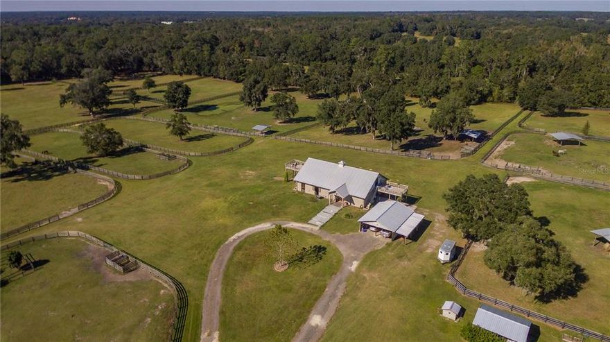 Nestled at the heart of the Horse Capital of the World® and overlooking 26+ acres of stunning Central Florida countryside, this beautiful horse farm offers a premiere location. Fenced and gated, the farm offers lots of flexibility for a variety of disciplines and  is mostly cleared with gentle shade provided by mature oaks. Active equestrians looking to get the most out of horse country will love the well-maintained center-aisle barn which includes a total of 7-stalls with auto-waterers, wash rack with hot and cold water, and barn office. The second floor of the barn features a stunning 1-bedroom, 1-bath barn apartment with reclaimed pine wood and travertine flooring, a full kitchen, full bath, sitting room, and gorgeous views of the surrounding farm from the large balcony. The guest house is a nicely appointed 1-bedroom, 1-bath mobile that features lots of natural light and wood-look flooring throughout. The kitchen provides lots of cabinet and counter space, stainless steel appliances, and breakfast bar. There are two covered patio areas that provide plenty of space for seating and absolutely stunning views of the nearby paddocks. For those who enjoy spending time working with their hands, the property’s workshop features full power, covered areas for large equipment storage, storage options, and a large built-in work table. Enjoy the best that NW Ocala has to offer with HITS only 10 minutes away and the new World Equestrian Center only a 15 minute drive. A variety of tack and feed stores, equine service providers, and veterinarians are also conveniently close by and a short drive will bring you to Downtown Ocala’s many shopping, dining, event, and medical options!