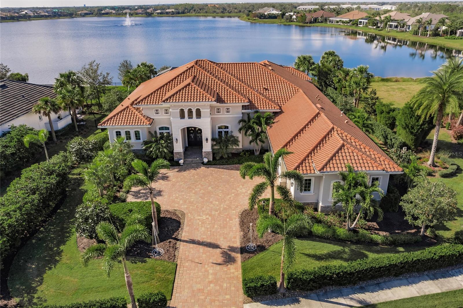 Absolutely stunning, one-of-a-kind dream home on Lake Como in The Lake Club. This extraordinary estate, nestled on a rare and private oversized lot along Lake Como, is surrounded by serene conservation areas and features breathtaking lake views from nearly every angle. Custom-designed landscaping ensures complete privacy, creating a tranquil oasis for the most discerning buyer. Exceptional Outdoor Living:
The heart of this home is the expansive 4,000-square-foot lanai, with 1,200 square feet under roof, doubling your living and entertaining space. Enjoy the travertine flooring, two outdoor fireplaces, a large mounted TV, and multiple sitting areas for relaxation or hosting. The centerpiece is the massive saltwater pool with a lap lane, spa, and extraordinary lighting. Adjacent to the pool, you'll find a dining area, outdoor kitchen, and enclosed pool storage room. Elegant Interior Design: Step inside through disappearing floor-to-ceiling pocket glass doors, seamlessly blending indoor and outdoor living. The great room features custom cabinetry and panoramic views of the lake. The formal dining room is complemented by a dry bar, perfect for entertaining. The home office/den boasts custom cabinetry and built-in workspaces with porcelain tile. The gourmet kitchen is a chef's dream, featuring two floating quartz islands, sub-Zero and Thermador appliances, custom soft-close cabinetry with glass tile backsplash, a coffee bar and walk-in pantry, and informal dining area with stunning lake views. Luxurious Private Suites: The master suite, located on a private wing, offers coffered ceilings, pool views, and two spacious walk-in closets. The spa-like master bathroom includes a double walk-in shower, soaking tub, and custom double vanities. On the opposite side, three additional bedrooms feature ensuite bathrooms and custom walk-in closets, ensuring comfort for family and guests.
Extraordinary Features: 800-bottle wine room, insulated and refrigerated for the wine enthusiast. Designer touches: Coffered ceilings, tray ceilings, wall niches, custom lighting, fans, and wall coverings. This one-of-a-kind estate is for the fastidious buyer seeking unparalleled luxury, privacy, and sophistication. The owners invested $250k into significant improvements, including whole house generator, remote controlled hurricane shutters, motorized interior shades, landscaping, and fencing. The home was independently appraised last year at $3.8M. Don’t miss the chance to own this masterpiece in The Lake Club. Check out the 3D tour and schedule your private showing today!