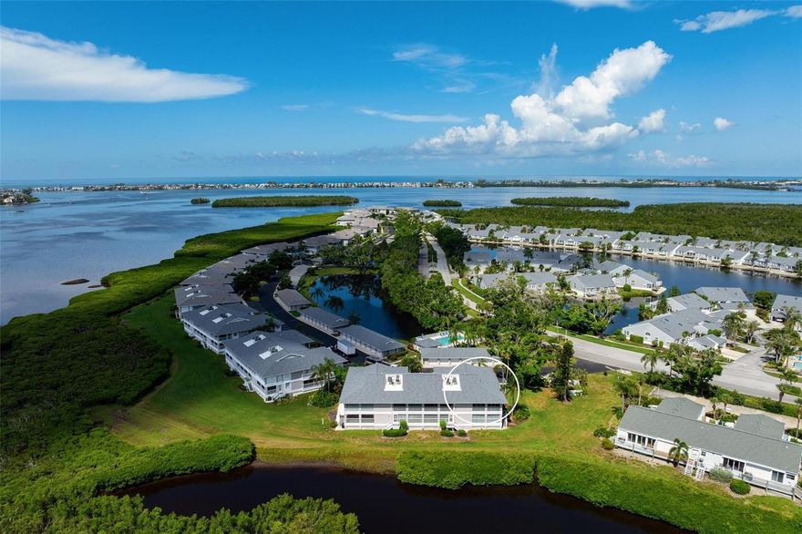 NEW ROOF and NEW A/C. Island Living at Its Best in the gated community of Perico Bay Club!  Welcome to this beautifully maintained second-floor end unit with expansive views of a peaceful lagoon and estuary, with Palma Sola Bay glistening in the distance. As the largest floor plan available in the community, this 3-bedroom condo offers spacious, light-filled living with vaulted ceilings and an open, airy layout. One of the bedrooms features charming barn doors and custom built-ins, making it ideal as a study, den, or guest space. The kitchen opens seamlessly to the dining area and includes a stacked washer/dryer for convenience. The primary suite is a private retreat, featuring a walk-in closet and a stunningly updated bath. Step out to the oversized enclosed lanai complete with a storage closet and enjoy birdwatching, entertaining, or simply relaxing while soaking in the tranquil water views. A shady side balcony adds additional outdoor space with views of lush greenery and water. Plantation shutters, and a new A/C make this unit move-in ready. A private 1-car garage is also included. This beautiful condo is offered unfurnished.  Perico Bay Club’s gated community offers resort-style amenities, including an Olympic-sized lap pool, a clubhouse with activities, pickleball and tennis courts, shuffleboard, swimming pools. Enjoy kayak/canoe launches (including one just behind this unit), plus storage and a walking pier. Located just minutes from the pristine beaches of Anna Maria Island, Robinson ,Neal, and Perico Preserves ideal for biking and nature walks. Enjoy local dining and shopping, this villa is perfectly positioned for enjoying Florida’s coastal lifestyle. Schedule your private showing today and experience the charm of this waterfront gem in Perico Bay Club! All just over the bridge from Anna Maria Island. Come see it today!