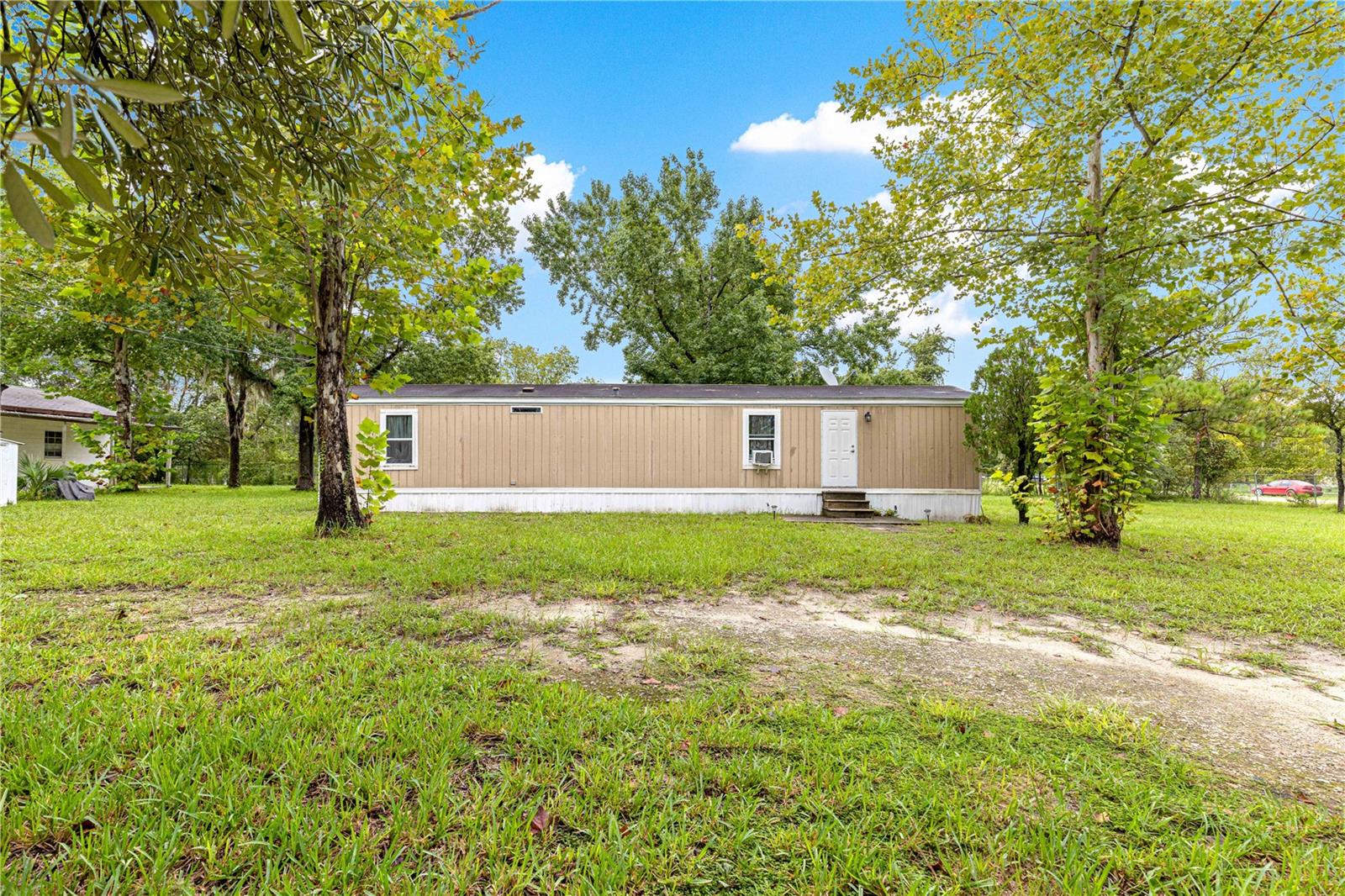 Turnkey 2-bedroom, 1.5-bath mobile home on 1.03 acres of fully fenced land, just 15 minutes from the World Equestrian Center, 10 minutes from Rainbow Springs, and only 15 minutes from shopping and local dining. Inside, you’ll find easy-care LVP flooring throughout, an enclosed back porch, and a deck perfect for relaxing or entertaining. The detached garage with power provides plenty of workspace, while two covered carports add convenience—each equipped with a 100-amp RV plug, and one side featuring a drain connection for RV septic. Extra storage is covered with both a shed and a storage pod on-site. With well and septic already in place, this property is ready for you to move right in and enjoy.