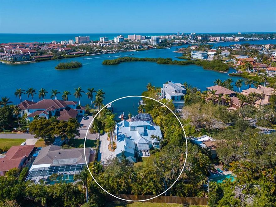 Less than 1 mile from Siesta Beach! Look no further as this gated waterfront estate, that is West of Trail and sits on a Huge lot, is just minutes to Siesta Key and the public beach. Rarely does a direct bayfront property on a lot this size come to market. Welcome to your fully gated and fenced, bay-front, private Mediterranean estate - the epitome of Florida's waterfront lifestyle! Enjoy each day with the sights and sounds of living on the Intracoastal: birds and otters frolicking, the light lapping of the bay, frequent dolphin sightings, and manatee swimming past will make your day. An idyllic location, at the end of a cul-de-sac, and the proximity to Stickney Point bridge ensures you will enjoy proximity to Siesta Key Beach, and Phillippi Farmers Market while enjoying breathtaking sunsets every evening. A boater's paradise, you will enjoy easy dockage on your private lift with a surrounding dock. This family home features privacy and security for your family as you enjoy the 3/4-acre lot (with space for a separate structure such as a guest house or sports court to be added) and pick some fruit from a variety of fruit trees. The waterfront yard is the perfect resting spot complete with a sandy area with hammock and fire pit area overlooking the bay. The screened lanai features a sun deck with in-ground pool, separate heated spa, covered eating area and covered pergola with a flat-screen TV. The downstairs master bedroom has sweeping views of the bay and pool, coffered ceilings, plantation shutters, glamorous master bath with new soaking tub, a walk-in Roman shower, bidet, window seat, and large custom walk-in closets. Downstairs you will find a formal living room, dining room, kitchen with open floor plan into the family room, granite counters, breakfast area, guest room with walk-in closet and bath, office and media room, laundry room with built-in desk, cabinets and wine rack. The exquisitely renovated kitchen has all-new 2021 appliances, Thermador gas cooktop, Sub-Zero fridge, and a dual wine refrigerator. Upstairs you will find more amazing views of the bay from 2 more bedrooms and a full bath. No detail has been overlooked in this bay front jewel, including a new metal roof in 2021, newly pavered driveway and 3-car garage with EV charging station. This West of the Trail home should be on your list to see.