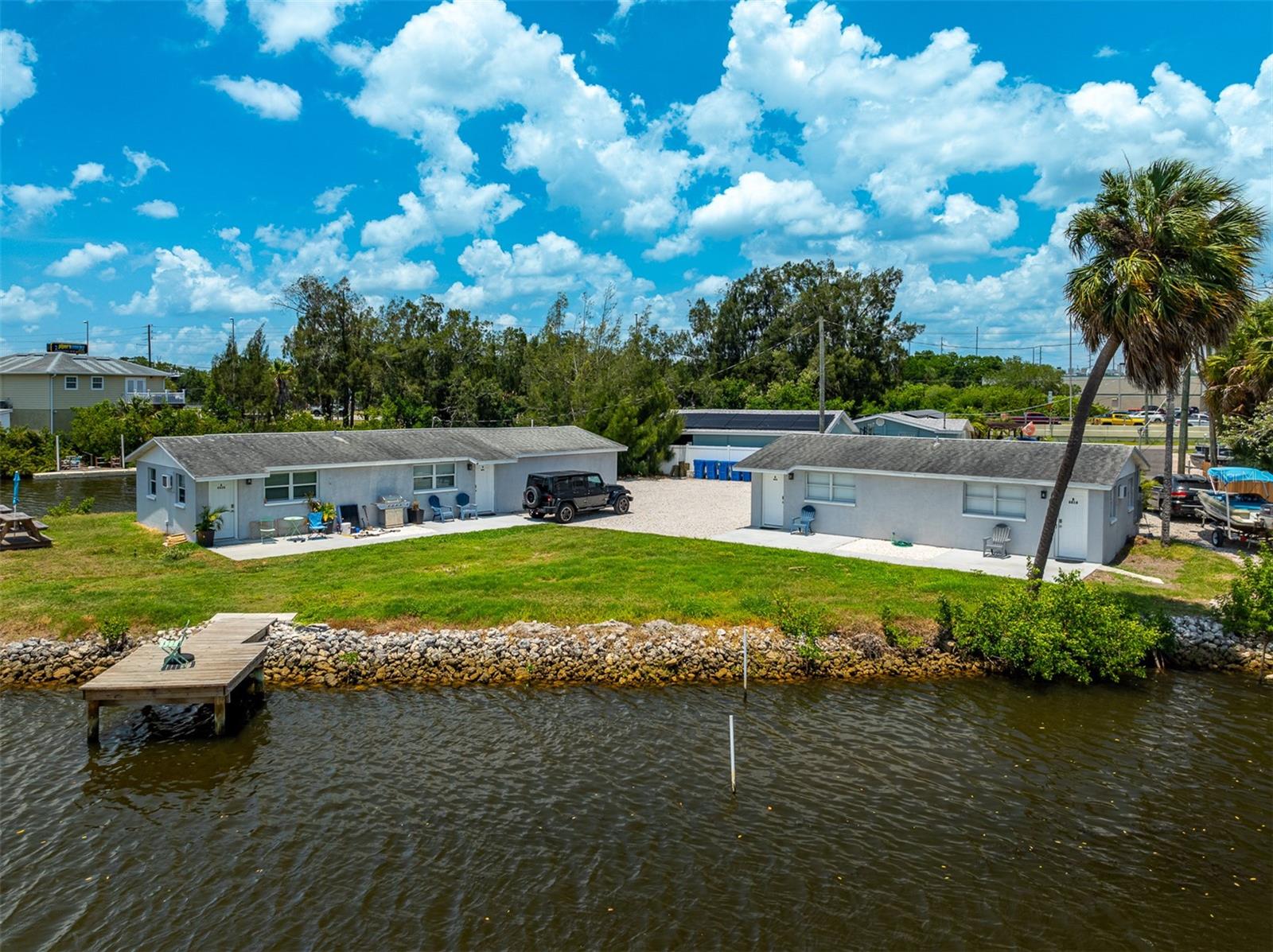 Exceptional waterfront investment opportunity awaits. This property is located on a peninsula of Rocky Creek offering well over 200 feet of waterfront with easy access to Tampa Bay and the Gulf. The land which consists of two duplexes affords opportunity for development to provide a substantial property. Duplex 8818 consists of two 1 bedroom, 1 bath units. While duplex 8820 consists of one 2 bedroom, 1 bath unit and a 1 bedroom, 1 bath unit as well as a shared laundry room. This property also features its own newly paved boat ramp and a wood dock perfect for fishing. Don’t wait, schedule a showing today!