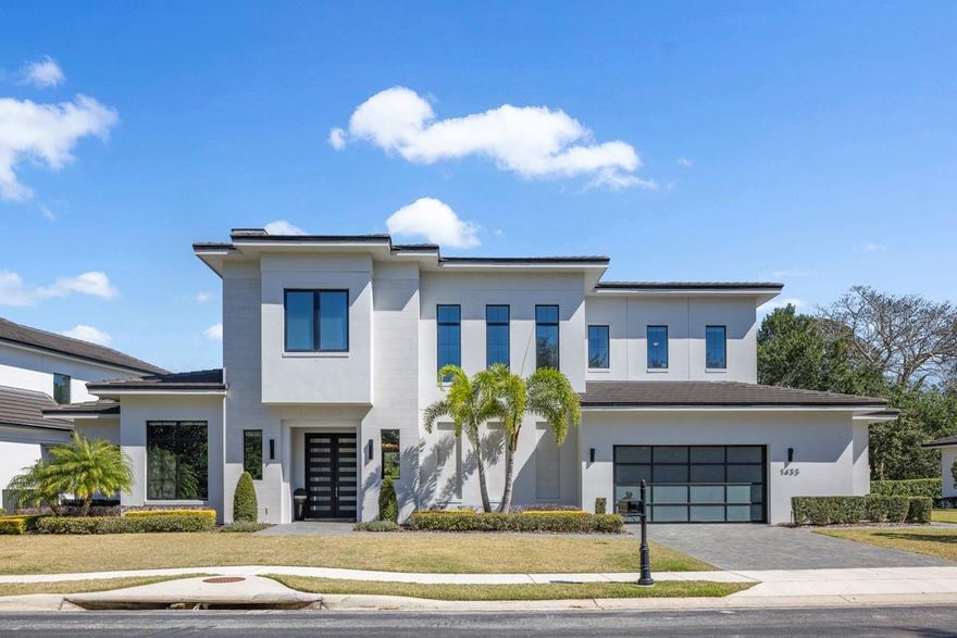 Welcome to this stunning custom-built residence in the privately gated Reserve at Interlachen, adjacent to Interlachen Country Club of Winter Park, Florida.  This pristine neighborhood has only nine custom homes with no neighbors in front and conservation behind the homes. Constructed in 2020 by Element Custom Home Builders. This meticulously designed home features an open floor plan that allows modern living, yielding spaces that allow the family to gather but also allows areas for private time. The comfortable family gathering area features hardwood flooring, a gas fireplace, and custom built-ins.  A wall of glass doors opens to the covered lanai, sparkling pool, and heated spa.  The modern kitchen utilizes function and form with top-of-the-line Thermadore appliances, lovely quartz countertops, a large walk-in pantry, and elegant custom cabinetry.
With an emphasis on Florida indoor/outdoor living the large covered lanai with summer kitchen, featuring a large grill and fridge, opens to the resort-style backyard. Enjoy your private oasis entertaining outdoors on the maintenance-free turf and relax with friends around the built-in gas fire pit.  Just off of the entrance a modern salon with a built-in lighted bar with a wine fridge can double as a private study.   Healthy natural light is carried through to the exceptionally pristine primary suite and luxurious master bath including a huge walk-in closet, his and hers quartz vanities, a vessel tub, and a walk-in shower.  The in-law or guest suite located on the first floor has easy access and is very private.  The upper level of this custom home consists of three bedrooms, each with its own bathroom and large closet. All bedrooms are centered around a large activity room, ideal for movie or game night.   This home is perfect for young families and empty-nesters. Close to shopping and restaurants along Park Avenue.  Walk to the YMCA and Phelps Park. Golf and tennis enthusiasts enjoy the neighborhood Racquet Club, Interlachen Country Club, and Winter Park 9 Golf Course.  
The newly constructed retaining wall creates a level backyard which has been outfitted with brand new Shawgrass Navigation Trek turf and a  14 X 14 gas built-in fire pit.  All light fixtures are custom-added by the owner.  The salon/study has custom built-ins and Cotton Pink Onyx countertops with built-in LED lighting.