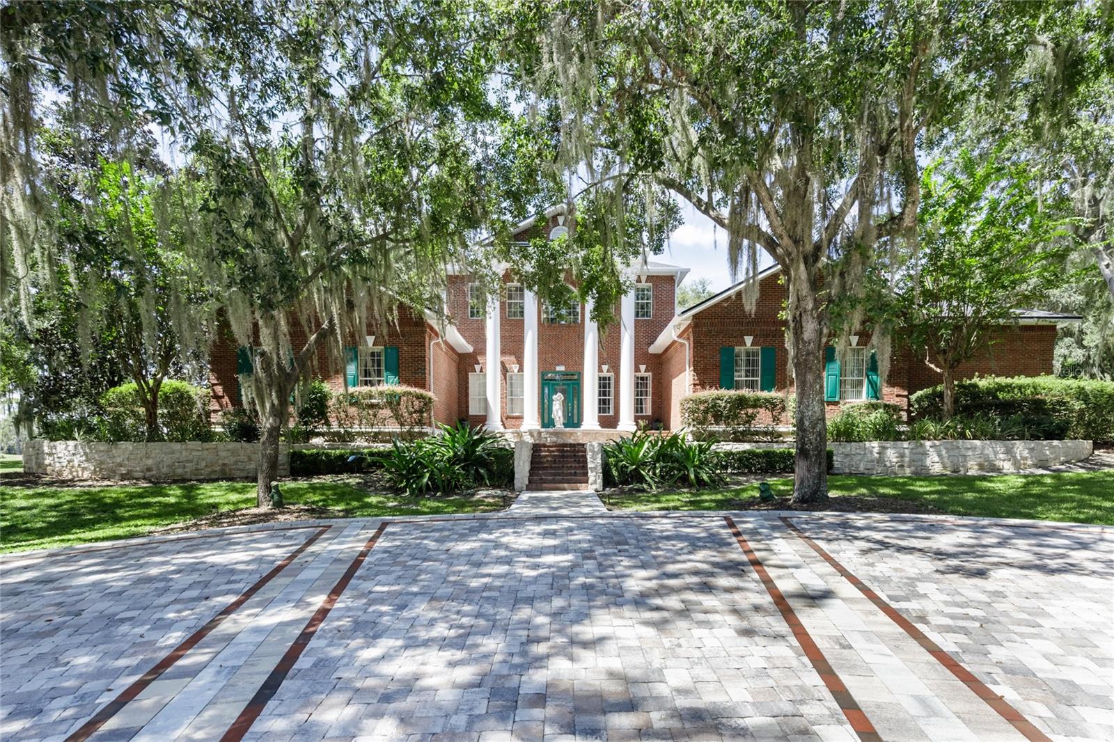 Stunning 5,300+ sq ft custom estate home on 3.46 acres with breathtaking views of Paine’s Prairie and the former Gainesville Country Club fairways. Built in 2000 with CMU block and brick veneer, this residence combines elegance and space. The home features 5 bedrooms, 4 bathrooms, a private office, billiard/game room with wet bar, and an gym under air. The owner’s suite and two bedrooms are on the main level, with two additional bedrooms upstairs. The spacious owner’s suite includes two deluxe walk-in closets with custom cabinetry and a separate tub and walk-in shower, a private toilet room with a bidet. Highlights include 12’ ceilings downstairs, 9’ ceilings upstairs, a grand foyer with columned entrance, formal dining room with built-ins, and a family room with theater-style seating, custom entertainment center, and 48" masonry fireplace. Additional features include a hurricane safe room with concrete walls/ceiling and steel door, electronics room, screened back patio, and an upstairs balcony with panoramic views. The 3-car rear entry garage offers an area that can be opened for RV storage. The property sits beyond the Gainesville Country Club clubhouse on a privately maintained road shared with only two other owners. Public water and sewer. Voluntary HOA; deed restriction applies. This is a rare opportunity to own a spacious estate with unmatched scenery, privacy, and amenities in a highly desirable location conveniently located near UF, hospitals, I-75, Celebration Pointe, dining & shopping . New roof installed in 2025 and 2 out of the 3 a/c's are newer.
