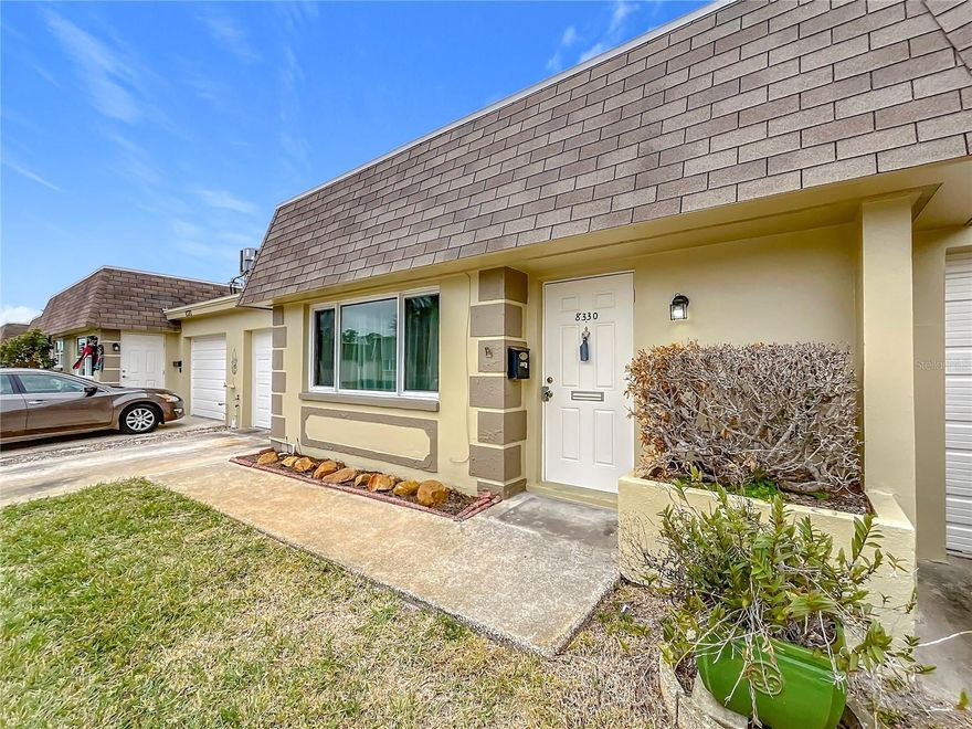NEW LOWER PRICE. This 55+ Villa is really a great value.  No damage from either hurricane. Updates include new HVAC in 2024. Windows and Roof replaced in 2020. It also has beautiful vinyl flooring throughout the living areas and bedroom. It has an attached garage with a washing machine and clothes dryer included in the sale. The large bedroom has a private bathroom PLUS there is a "powder room" (half-bath) for your guests.  This home backs up to the residential neighborhood, so no rear neighbors and a nice "back yard" patio. The owners built a wall to divide the kitchen and dining area. This was intended as a guest bedroom but works great as an office or crafting room. Association includes Water, Sewer, Trash, Cable, Internet, Building roof & exterior maintenance and Flood Insurance, Exterior Maintenance, Pool, Clubhouse and common areas. Residents of Vendome Village enjoy fantastic community amenities, including a heated pool, clubhouse, and shuffleboard & bocce ball courts. Centrally located just minutes to banking, shopping and dining. Only 10 miles to the Award-winning Gulf coast beaches and 30 minutes to Tampa International Airport.
