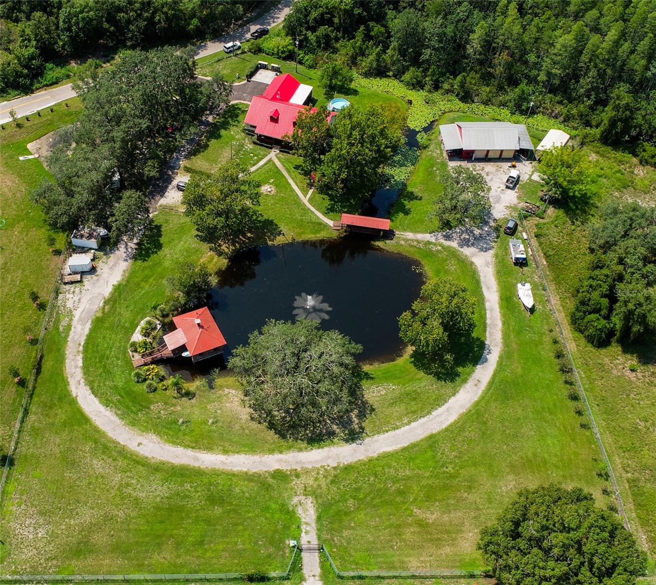 IT'S Incredible! LIVE, WORK, and PLAY ALL on 3.5 acres. It has 330 ft. on SR 52. Comfortable 3 bedroom, 2 bath home. First bathroom has a tub and a separate shower. The other bath has a large shower stall. The bedrooms are large, could be a 4 bed, if you used the upstairs loft room. Office space on the first floor. It has a large kitchen, with a cove around the stove. Eat off countertop and room for a dining room table. You can sit on the front porch overlooking the fish filled pond or take a walk across the covered bridge to the 3 plus car garage. A man cave is there, with an A/C. A boat house is on the pond with a view of the fountain. Electric and water are already available. Fans, screening are available when the bugs are bad. There is an RV space under the shade trees. There's so much more ! It all could be yours! Make an appt.