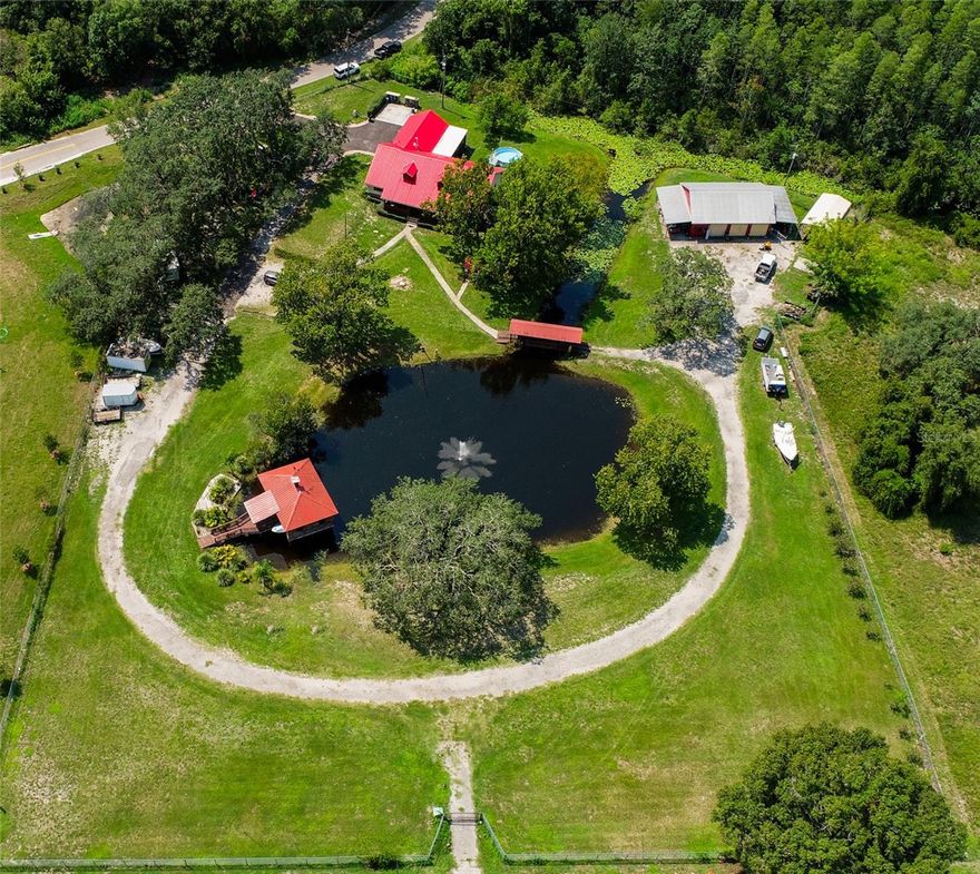 IT'S Incredible! LIVE, WORK, and PLAY ALL on 3.5 acres. It has 330 ft. on SR 52. Comfortable 3 bedroom, 2 bath home. First bathroom has a tub and a separate shower. The other bath has a large shower stall. The bedrooms are large, could be a 4 bed, if you used the upstairs loft room.  Office space on the first floor. It has a large kitchen, with a cove around the stove. Eat off countertop and room for a dining room table. You can sit on the front porch overlooking the fish filled pond or take a walk across the covered bridge to the 3 plus car garage. A man cave is there, with an A/C. A boat house is on the pond with a view of the fountain. Electric and water are already available. Fans, screening are available when the bugs are bad. There is an RV space under the shade trees.  There's so much more ! It all could be yours! Make an appt.